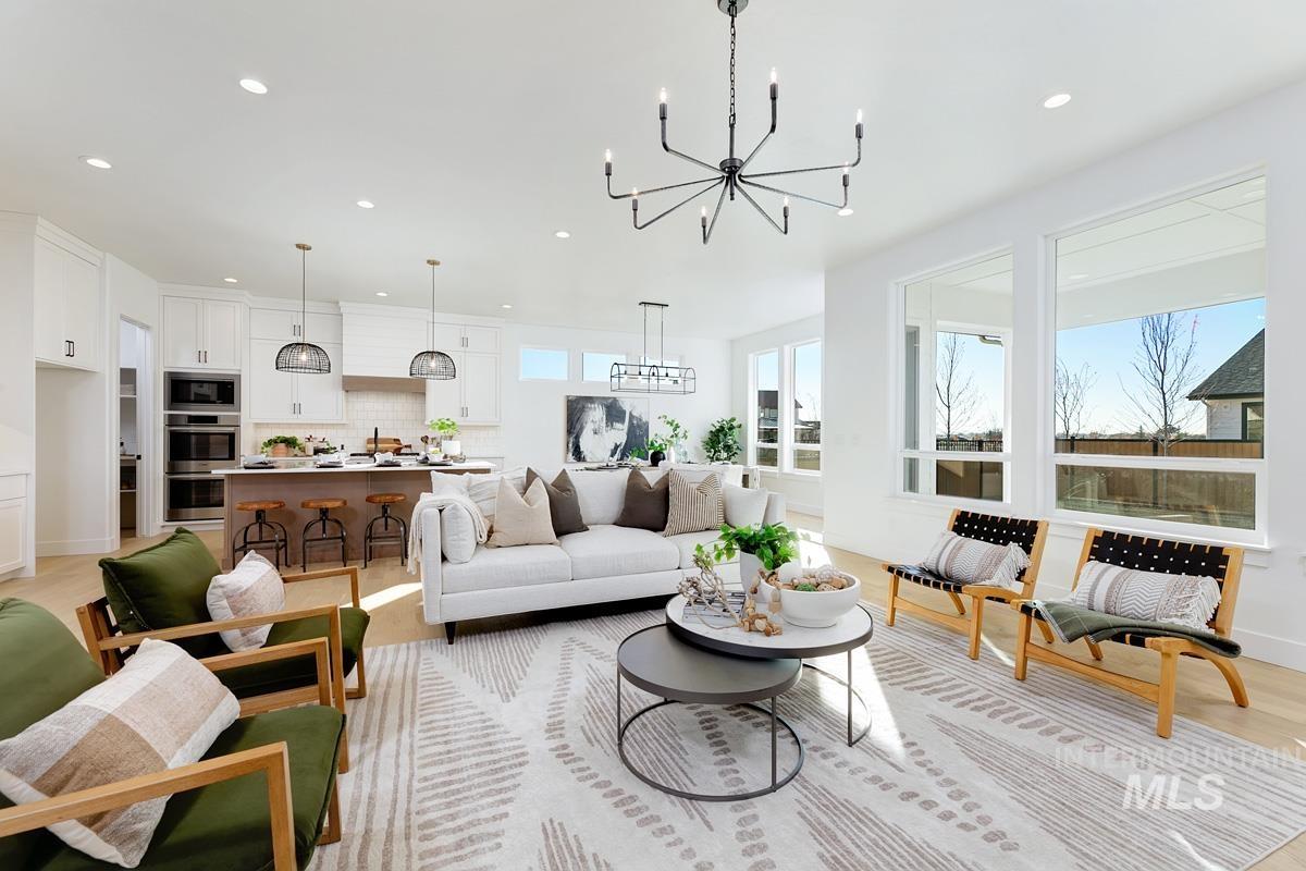 Living room with recessed lighting, light wood-style flooring, and a chandelier