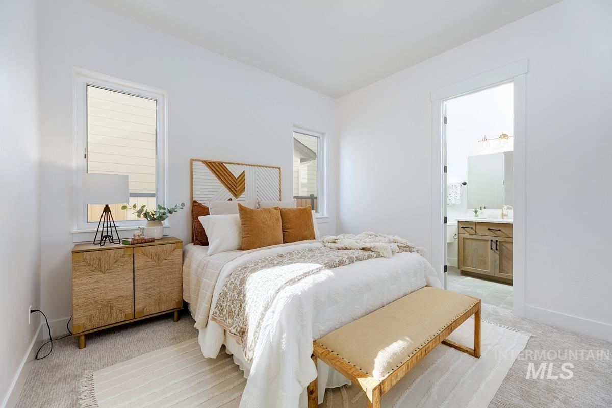 Bedroom featuring light colored carpet and ensuite bathroom