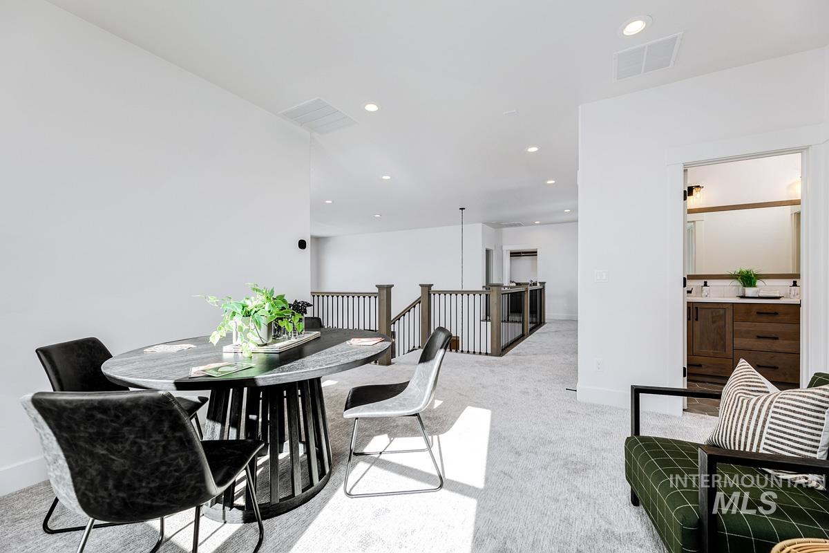 Dining area with recessed lighting and light carpet