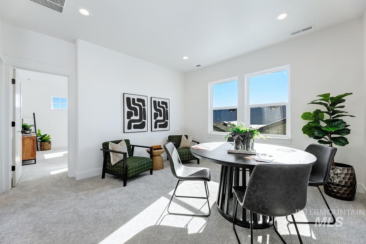Dining room with light colored carpet and recessed lighting