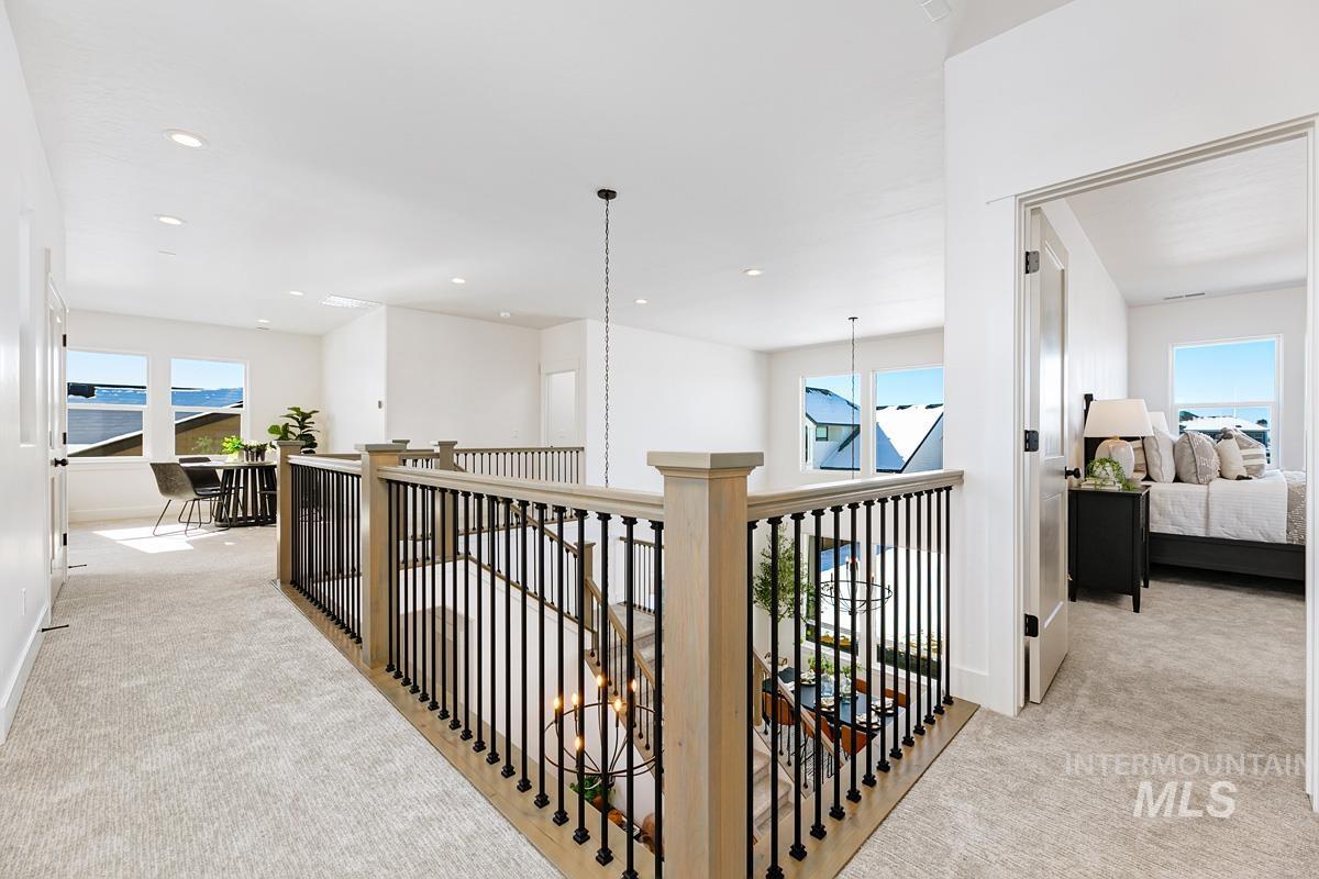 Corridor with light colored carpet, an upstairs landing, recessed lighting, and a chandelier