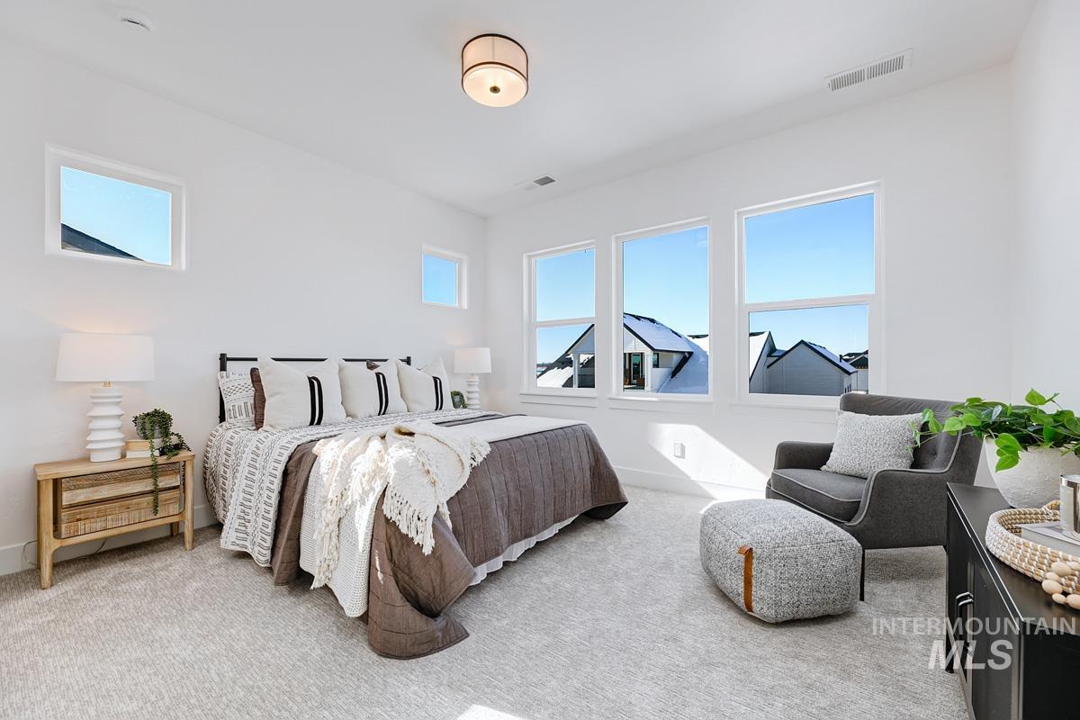 Carpeted bedroom with multiple windows
