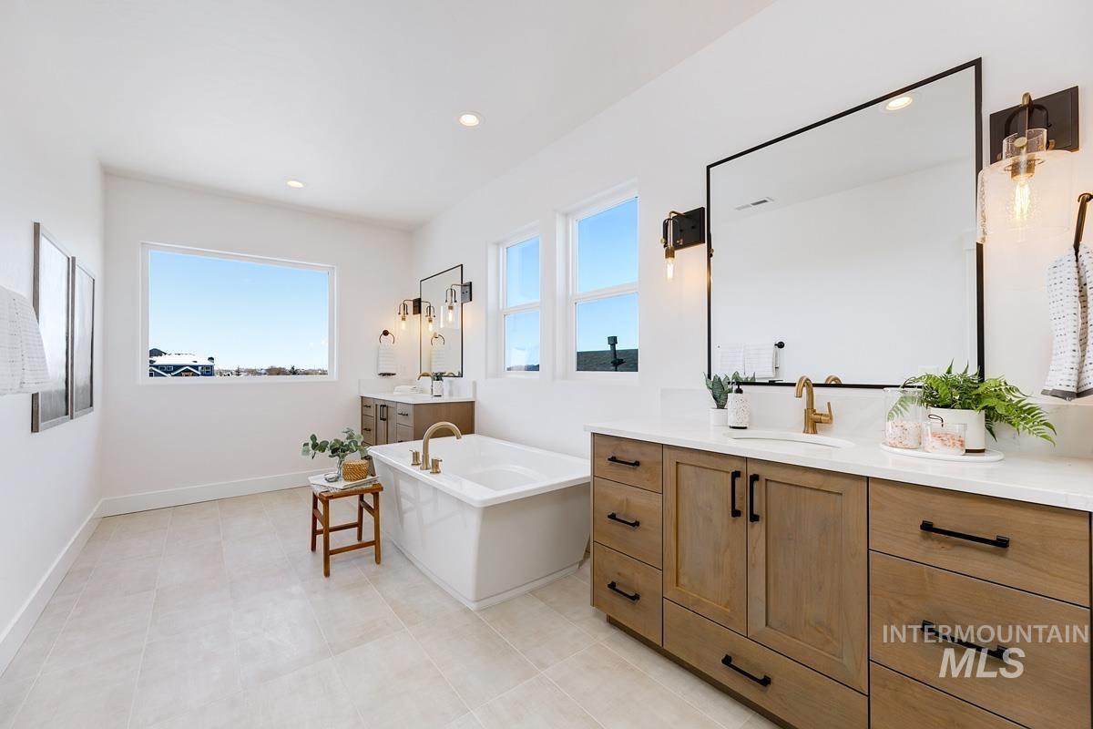 Full bath featuring two vanities, recessed lighting, a bath, and light tile patterned floors