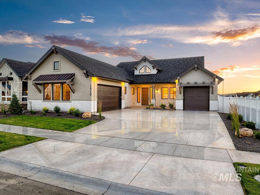 Modern farmhouse style home with stucco siding, a garage, concrete driveway, and brick siding