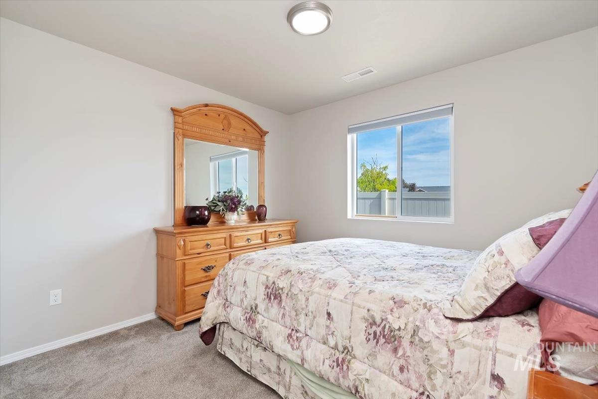 Bedroom with light colored carpet and baseboards