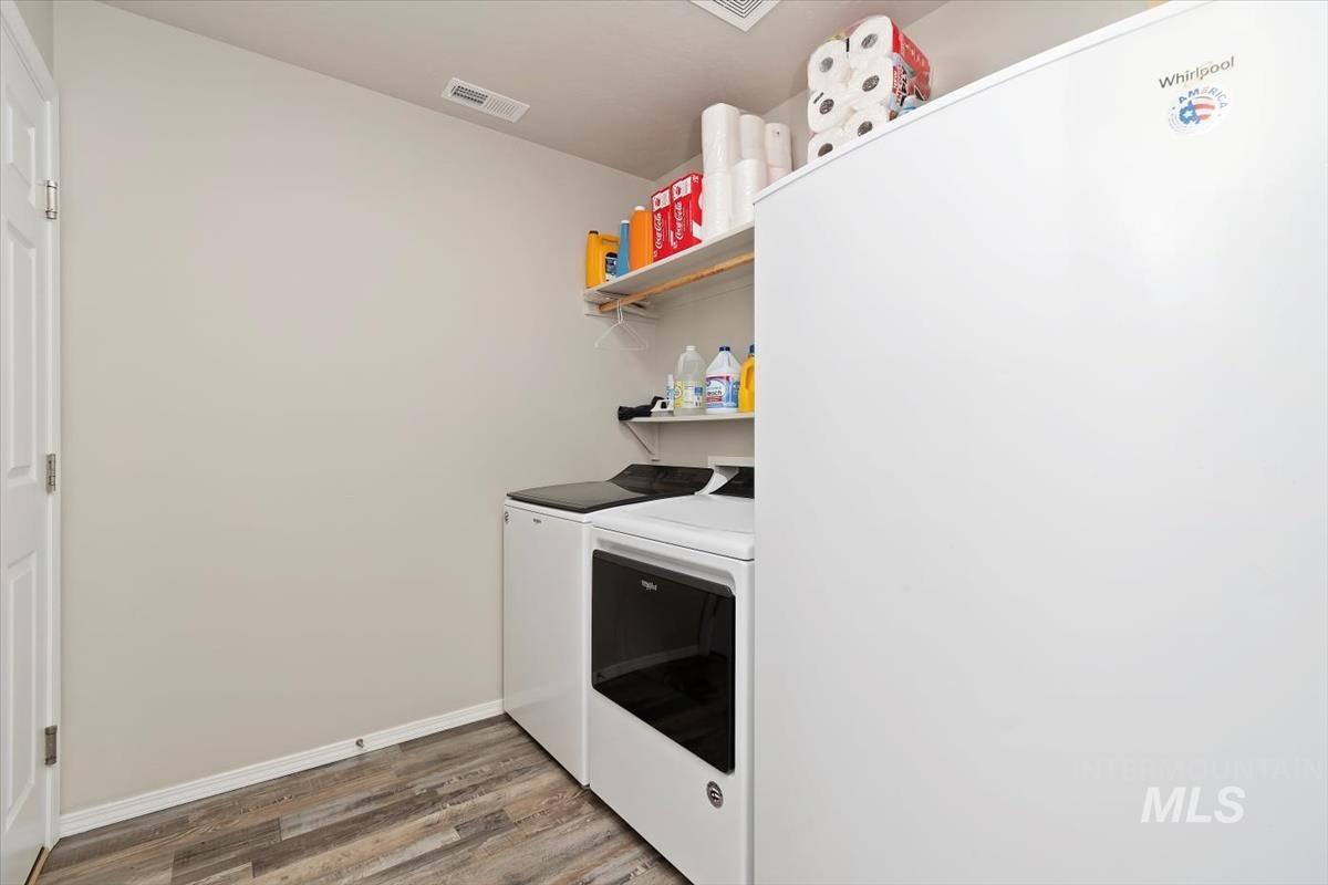 Laundry area featuring light wood-type flooring and washer and clothes dryer