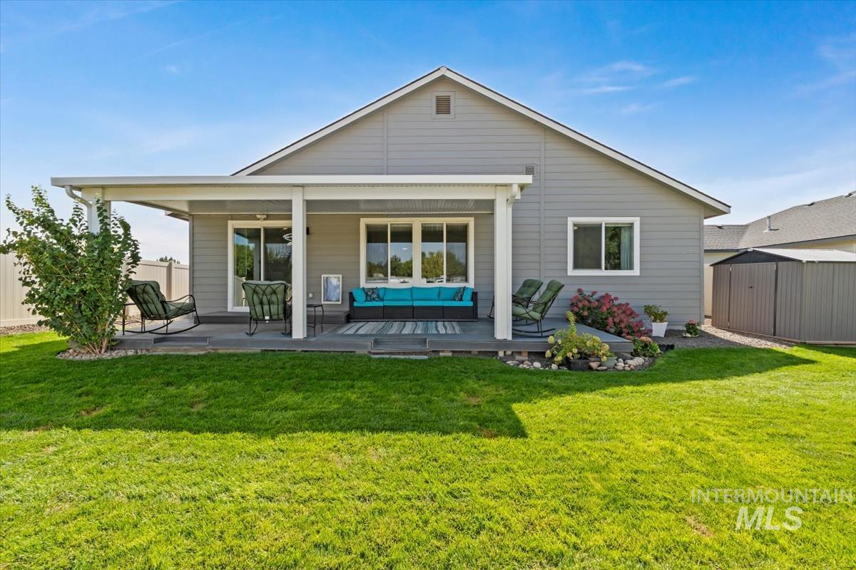 Rear view of property featuring a storage shed and a wooden deck