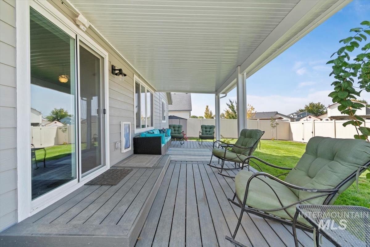 Wooden terrace featuring a fenced backyard and an outdoor hangout area