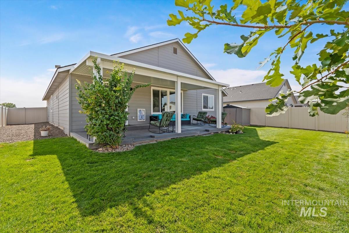 Rear view of property with a fenced backyard and a shed
