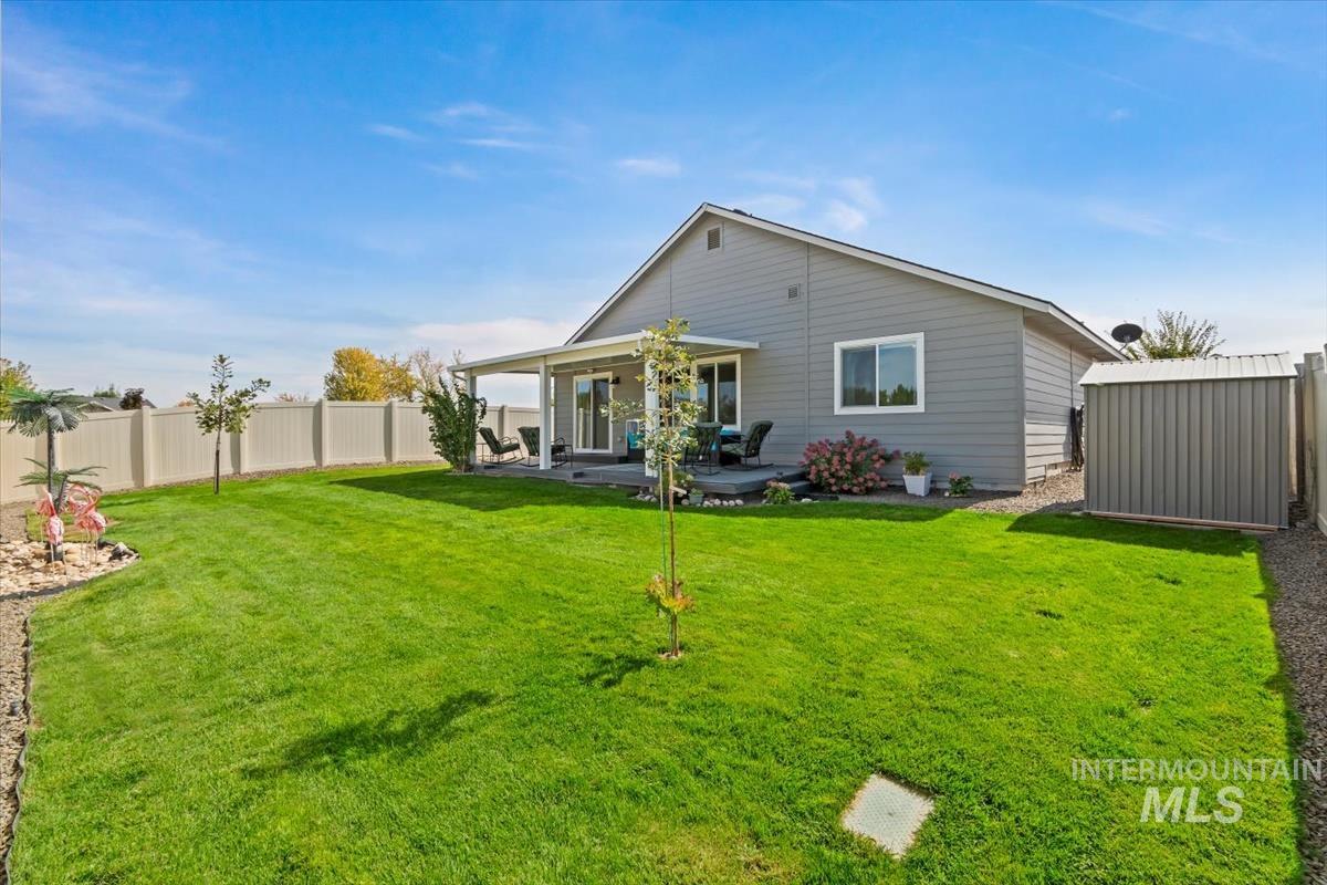 Back of property with a patio area, a fenced backyard, and a storage shed