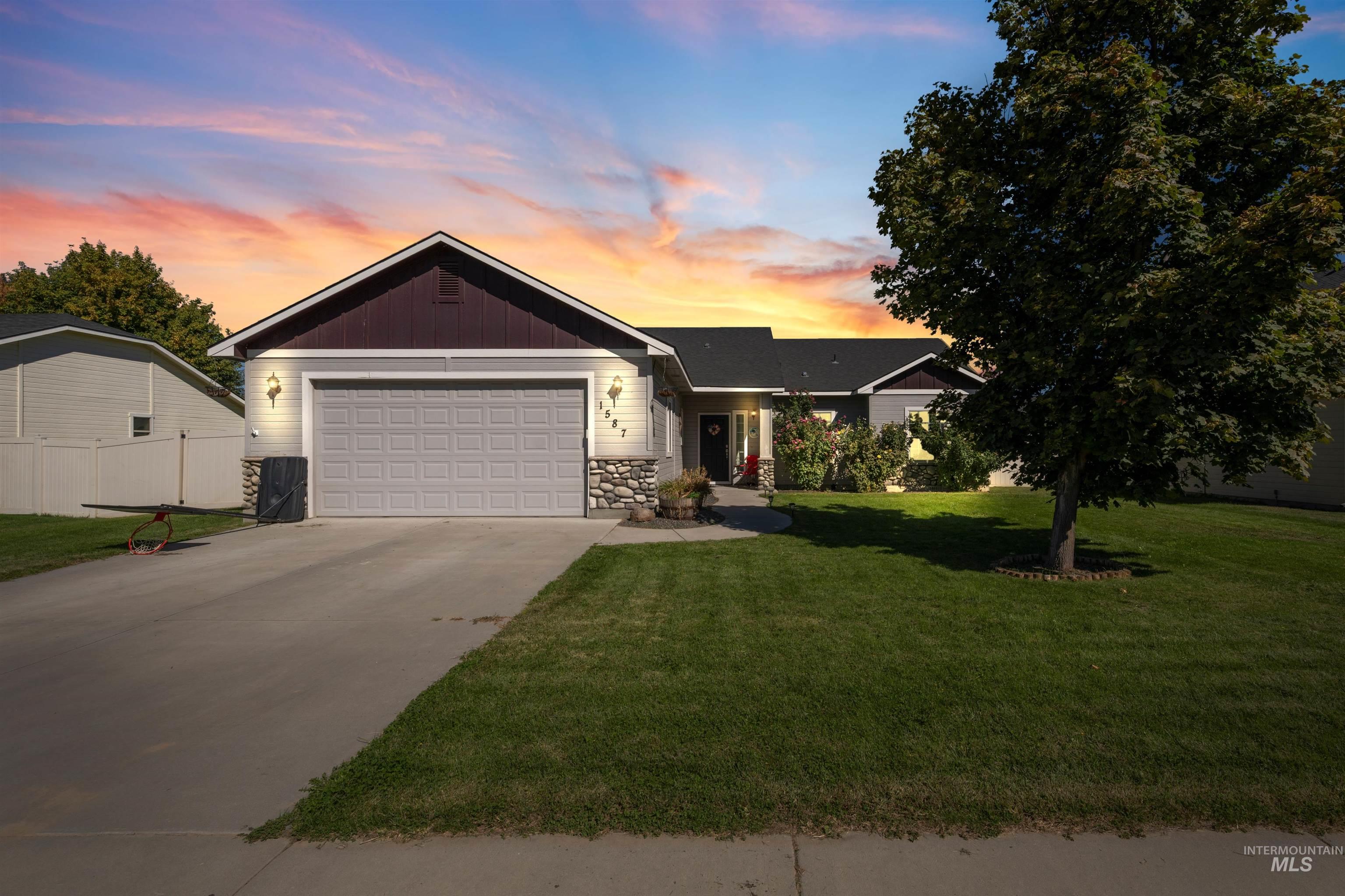Ranch-style home featuring stone siding, concrete driveway, and an attached garage