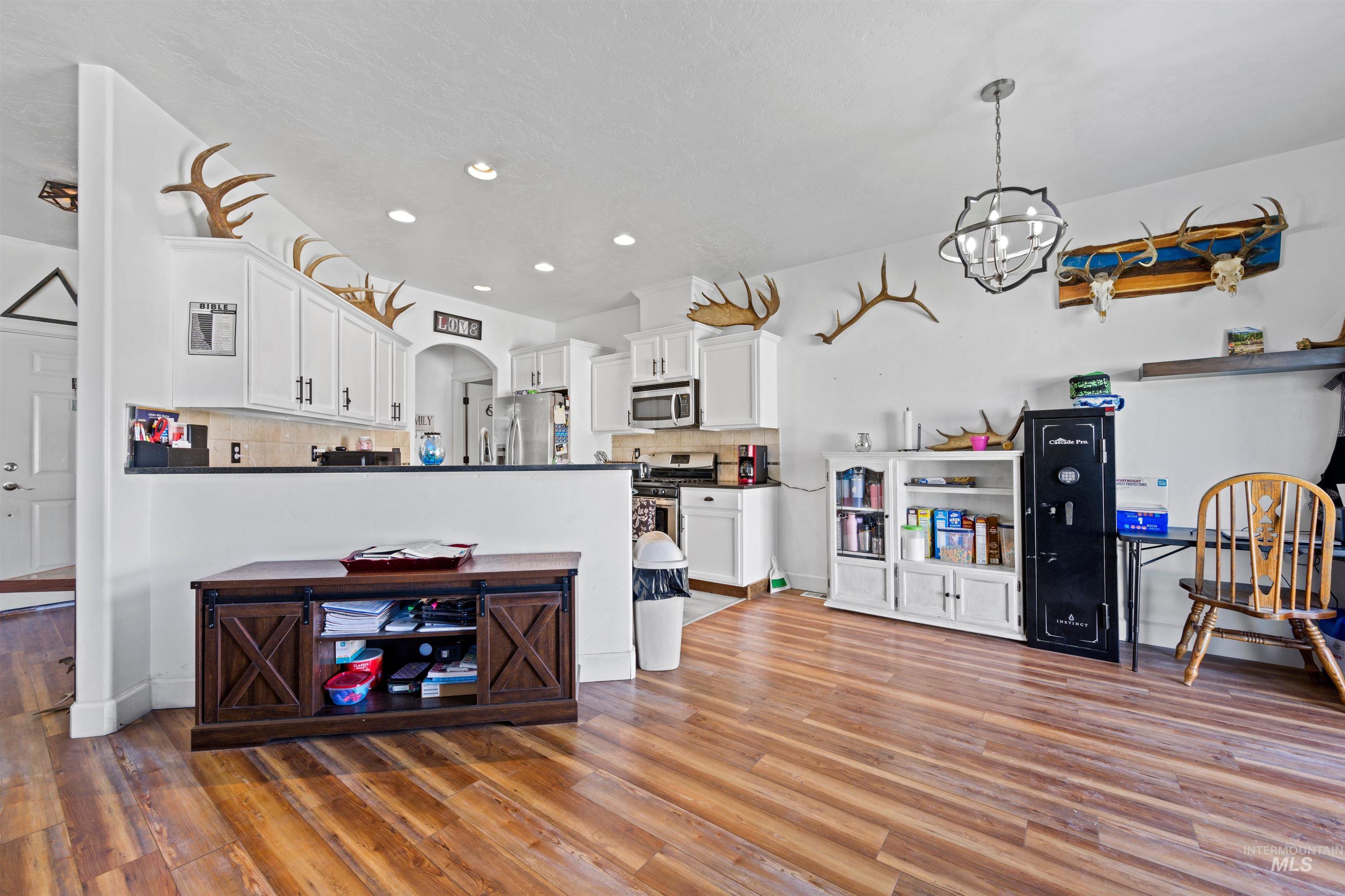 Kitchen featuring dark countertops, white cabinetry, tasteful backsplash, and recessed lighting