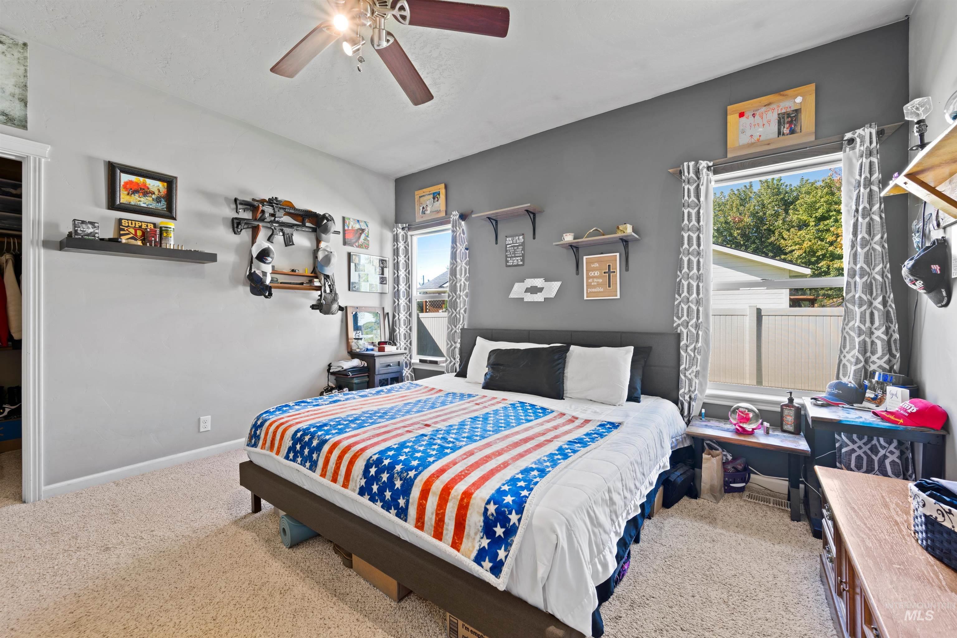 Bedroom with light carpet and a ceiling fan