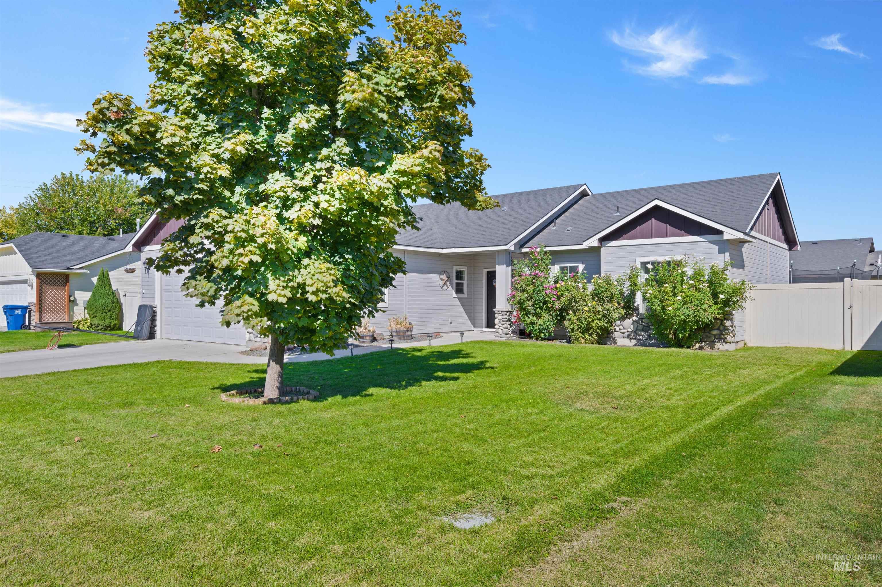 View of front of home with concrete driveway, roof with shingles, and an attached garage