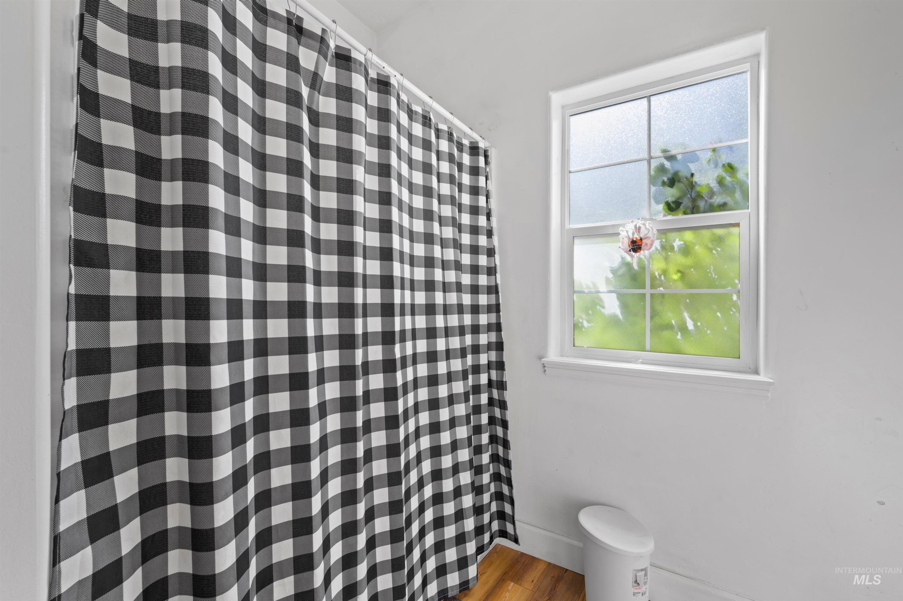 Full bathroom with a shower with curtain and light wood-style flooring