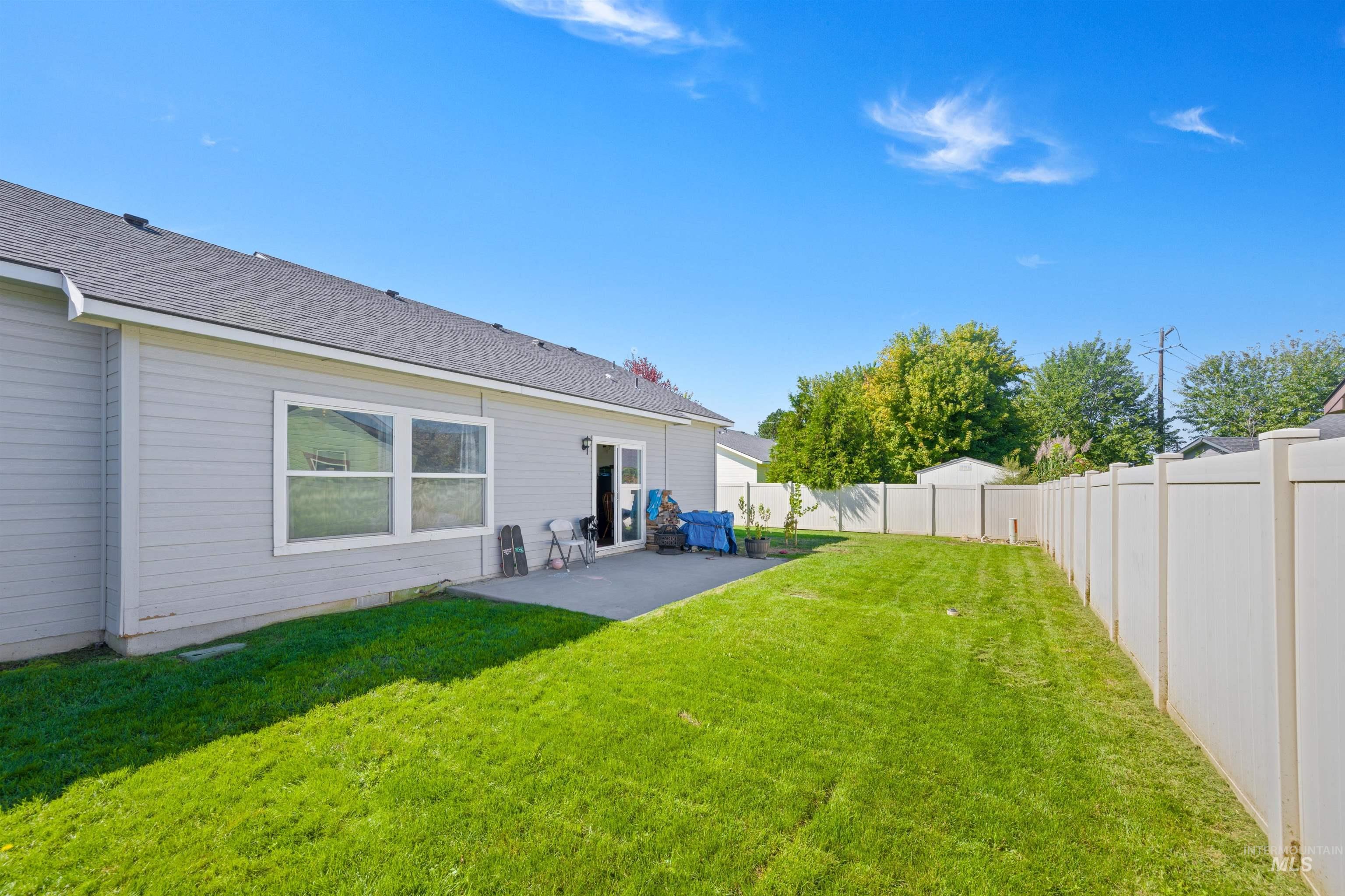 Back of property featuring a patio area, a fenced backyard, and a shingled roof