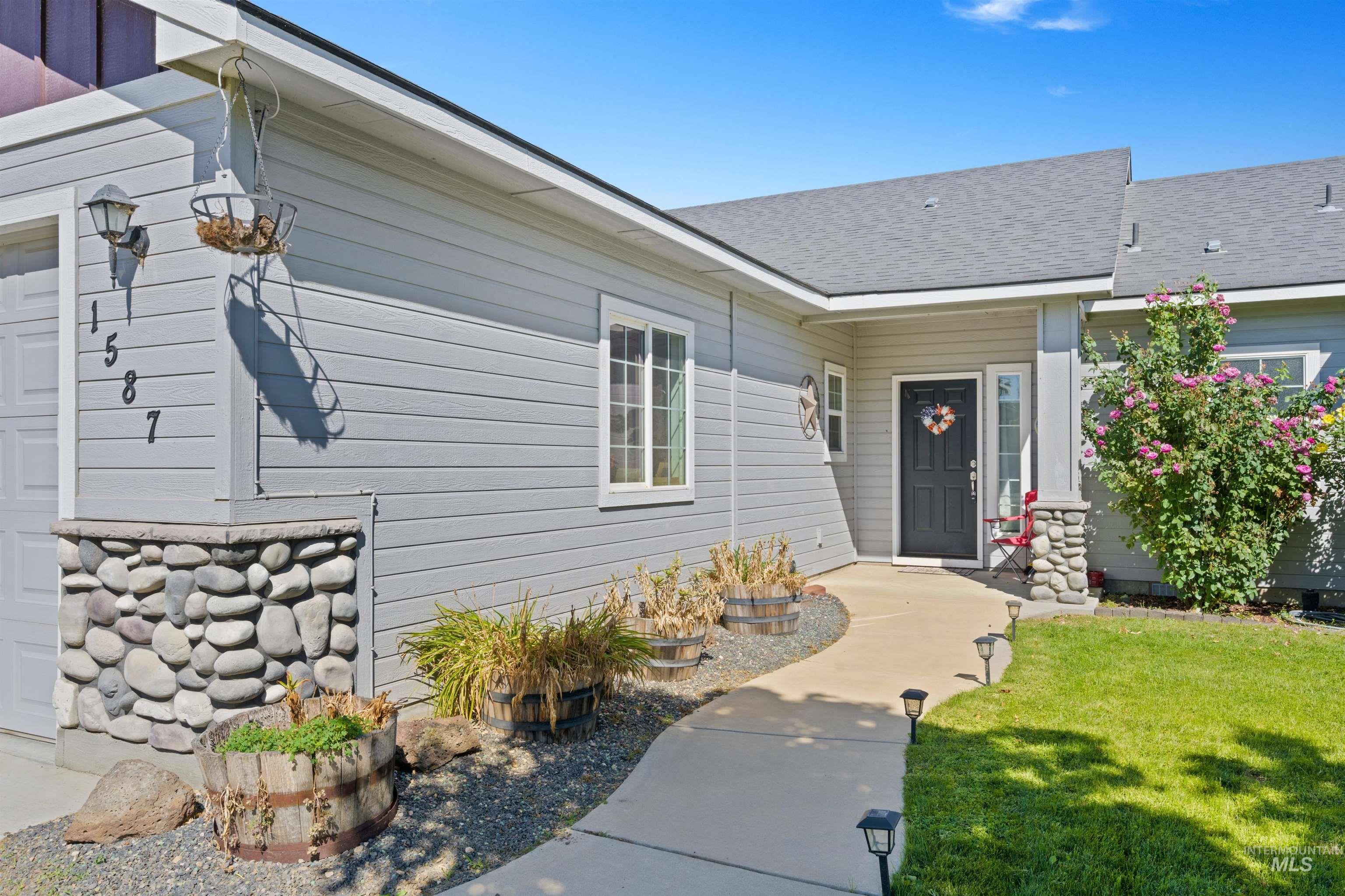 Entrance to property with roof with shingles and a lawn
