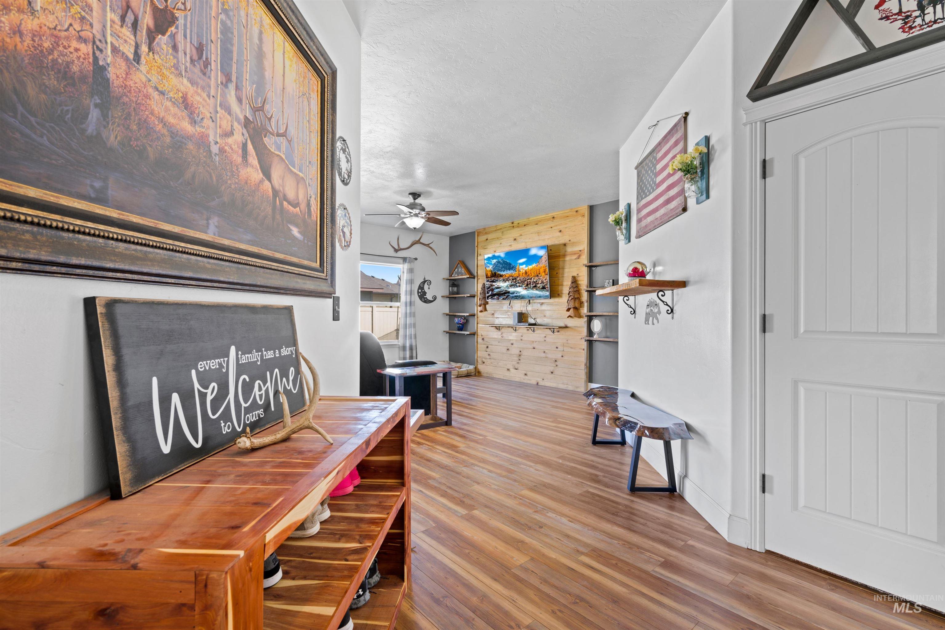 Dining space with light wood-style flooring, a ceiling fan, and wooden walls