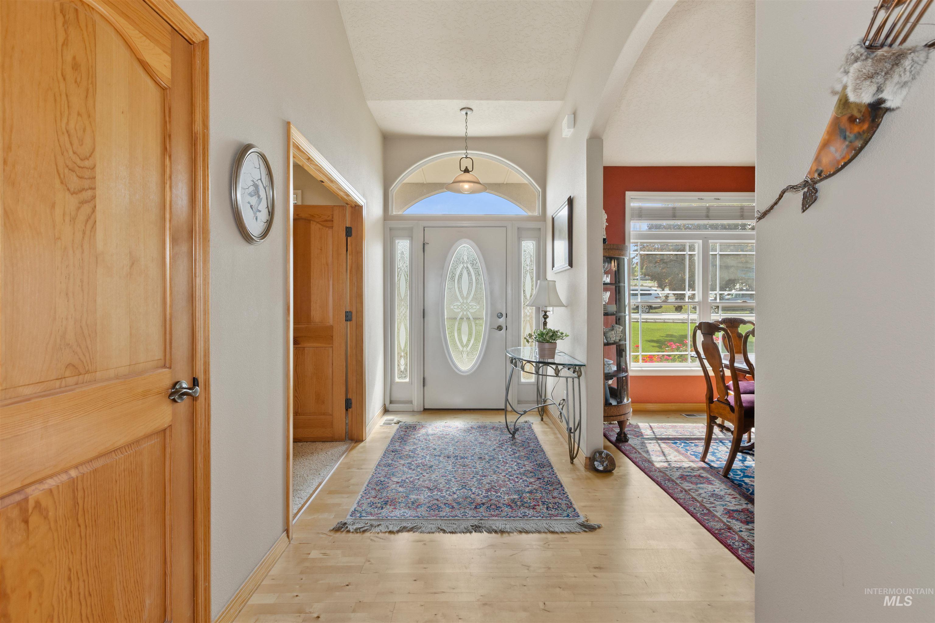 Foyer entrance featuring light wood finished floors and arched walkways