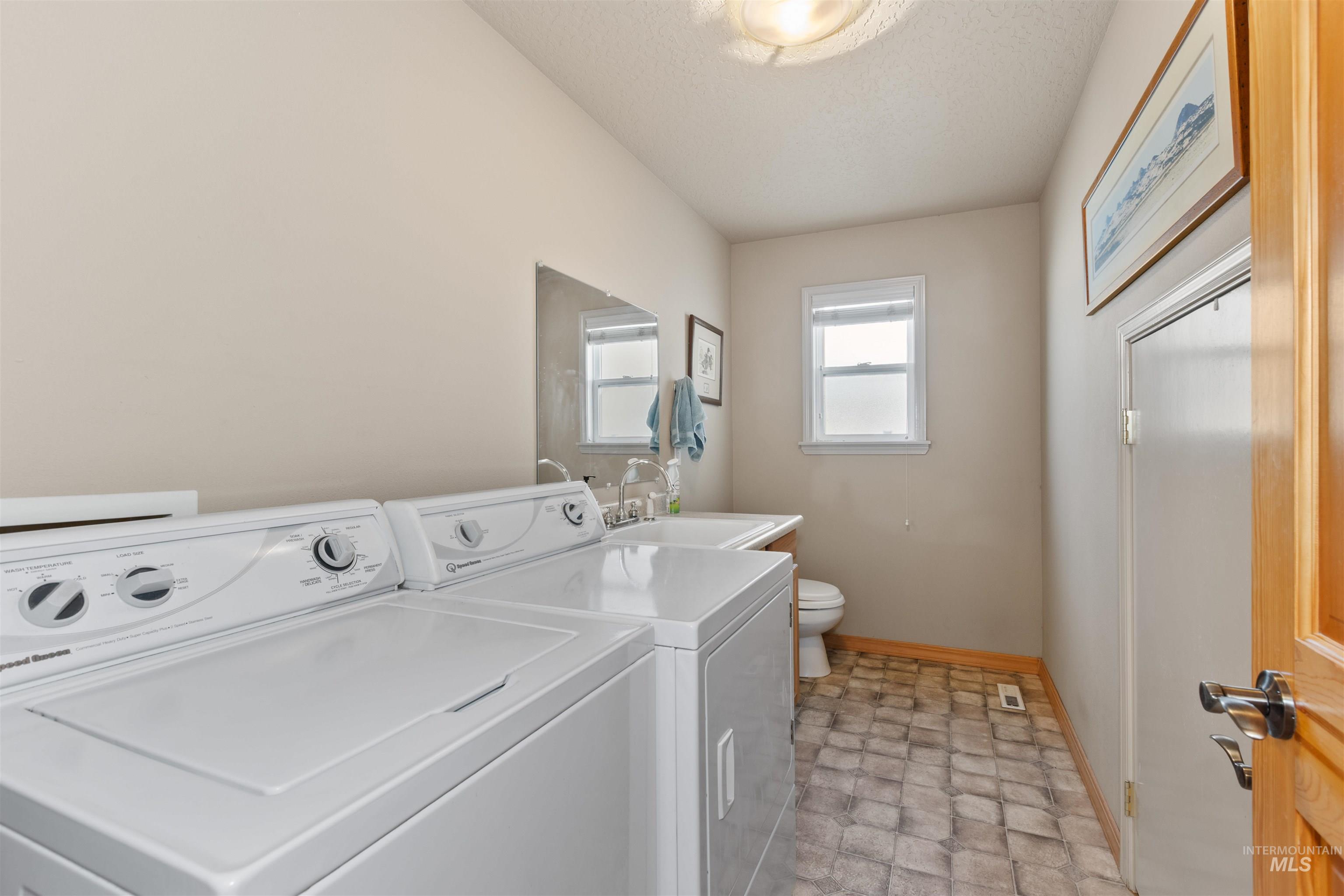 Laundry room with washer and dryer and a textured ceiling