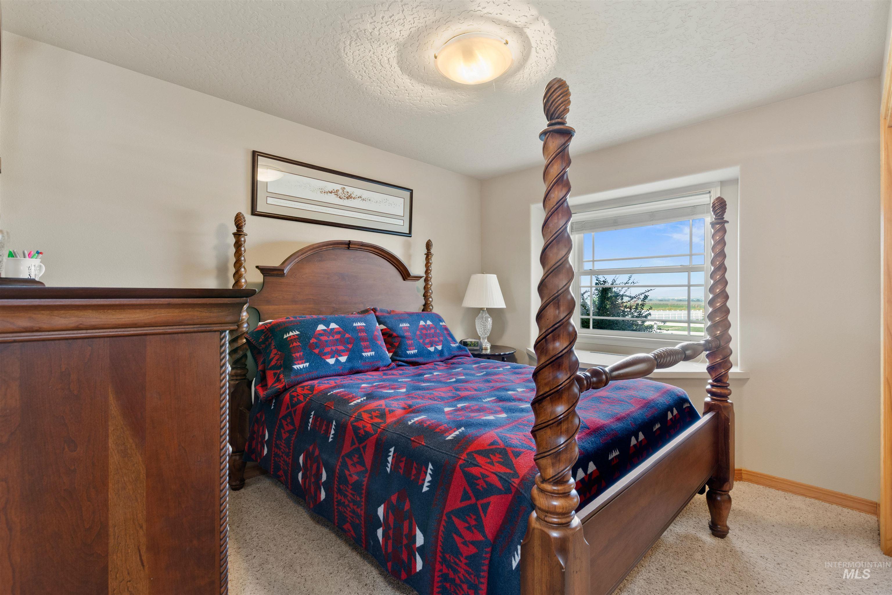 Bedroom featuring a textured ceiling and light carpet