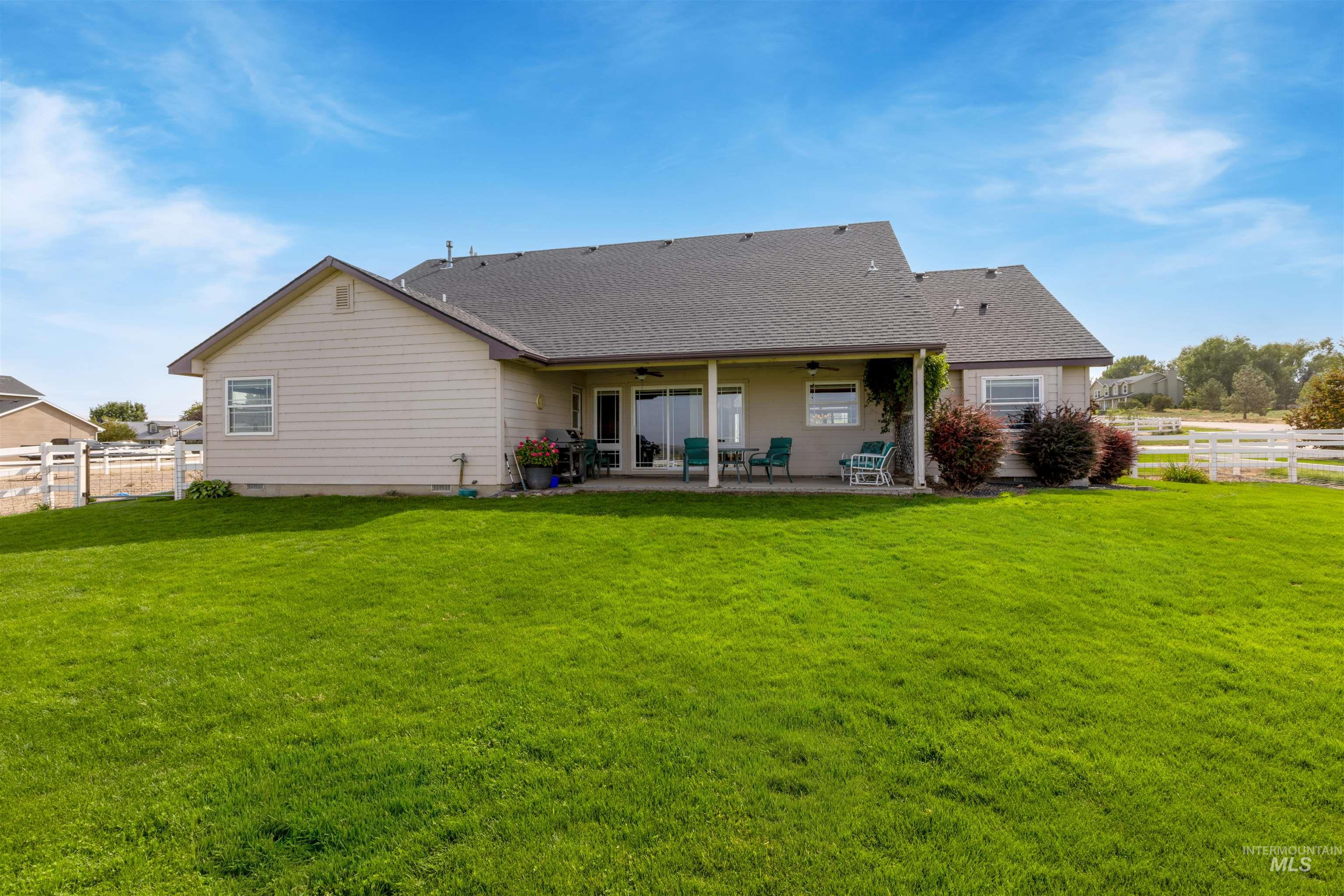 Back of house featuring a ceiling fan, a patio, and a shingled roof