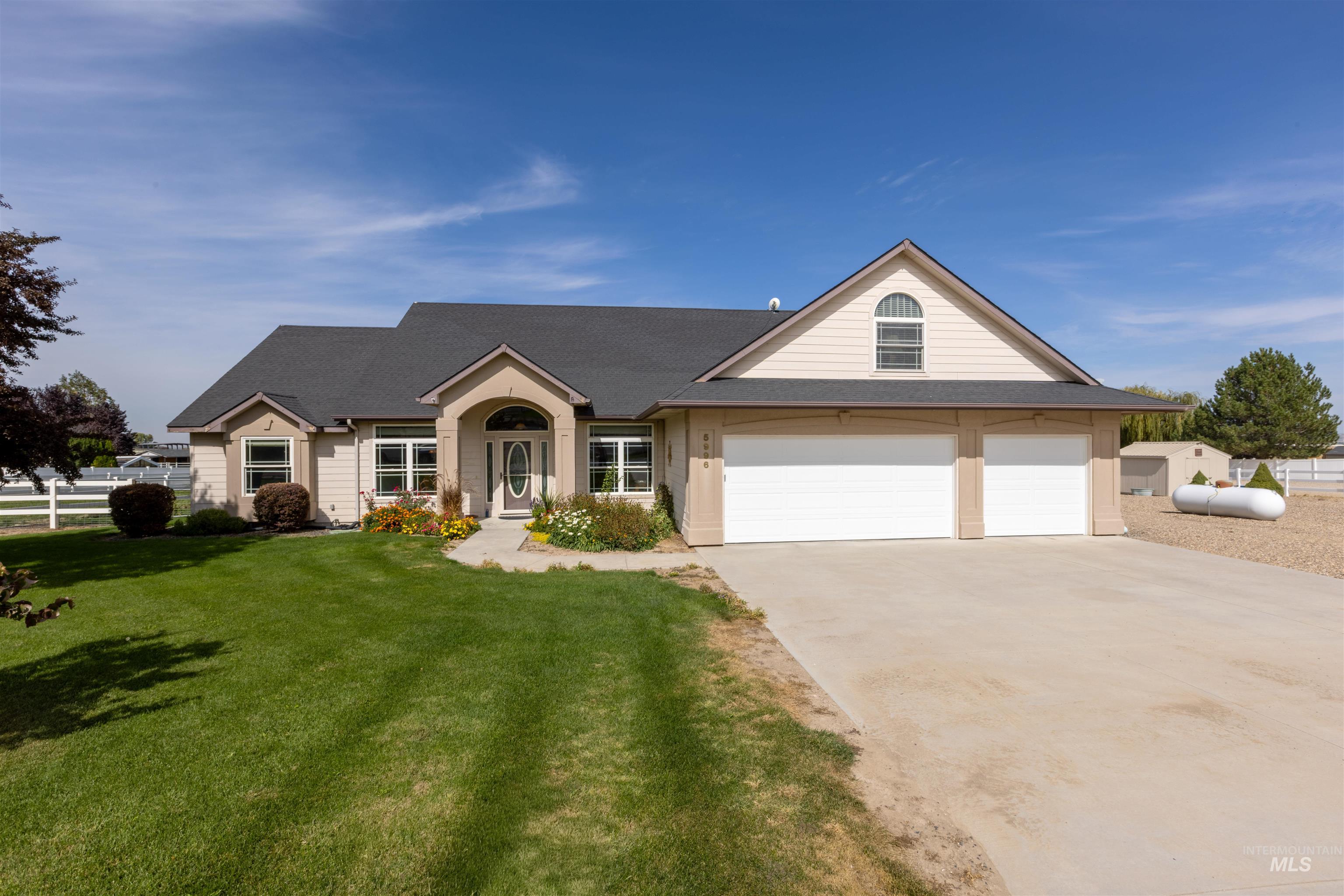 View of front of home featuring driveway, a garage, and a shingled roof