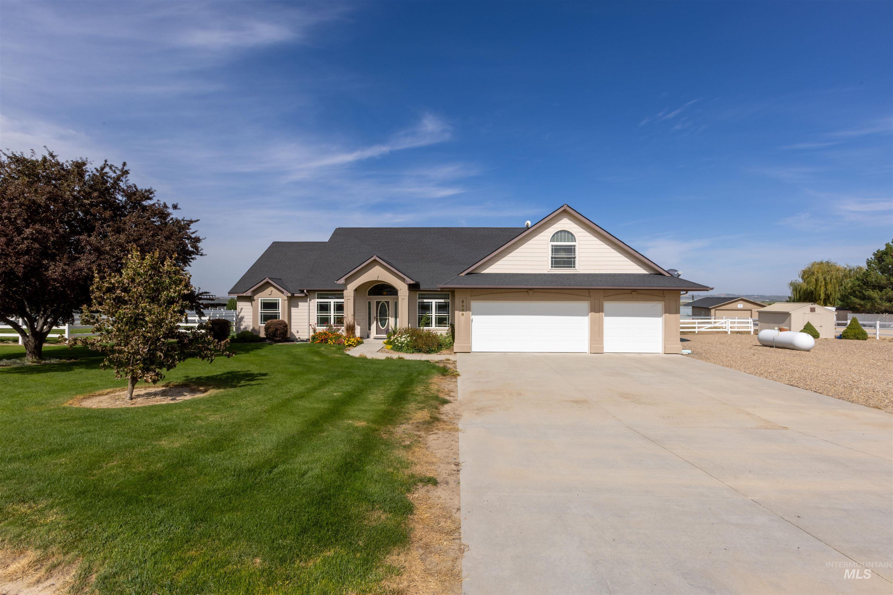 View of front of home featuring concrete driveway, a garage, a front lawn, and roof with shingles