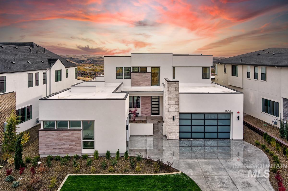 Modern home featuring stucco siding, stone siding, and concrete driveway