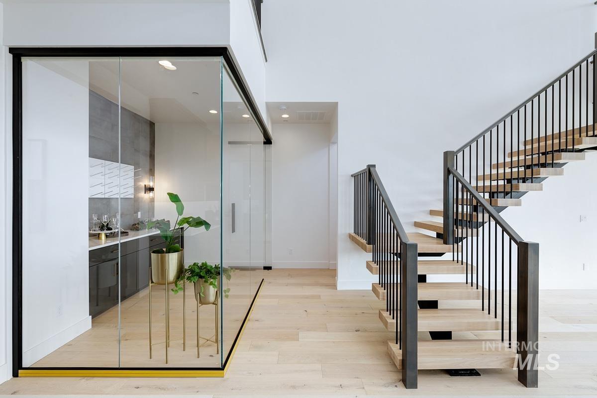 Stairway with wood finished floors and recessed lighting