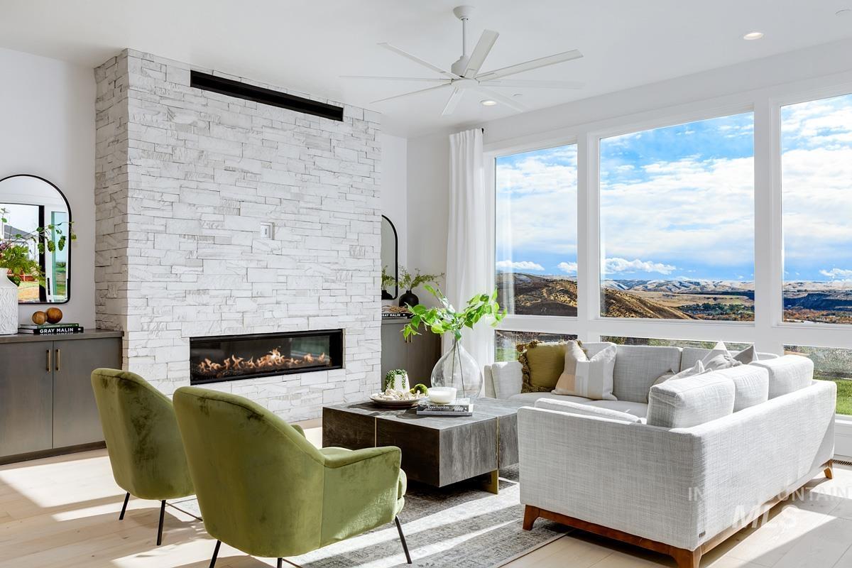 Living area featuring a ceiling fan, a fireplace, wood finished floors, and recessed lighting