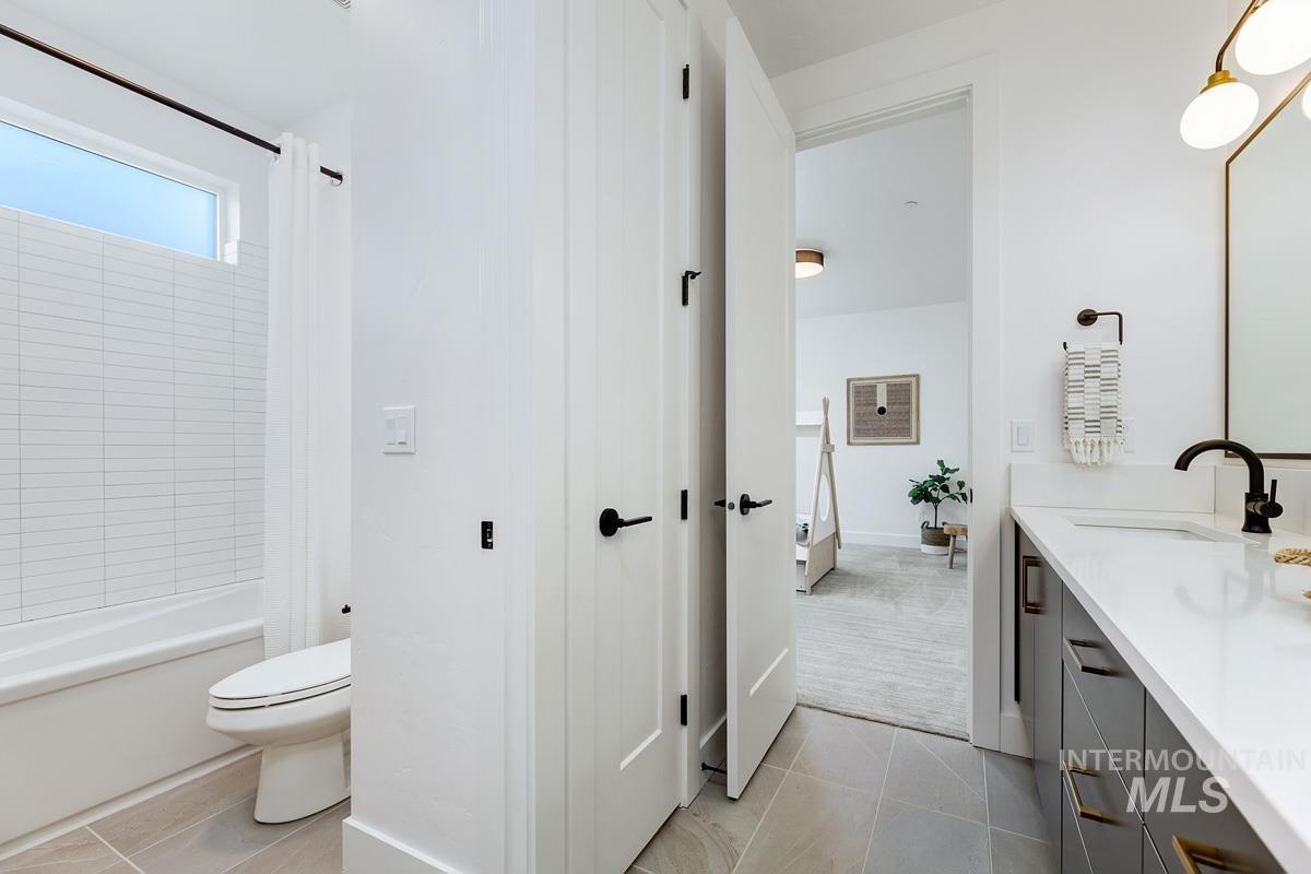 Bathroom with vanity, light tile patterned floors, and shower / bath combo