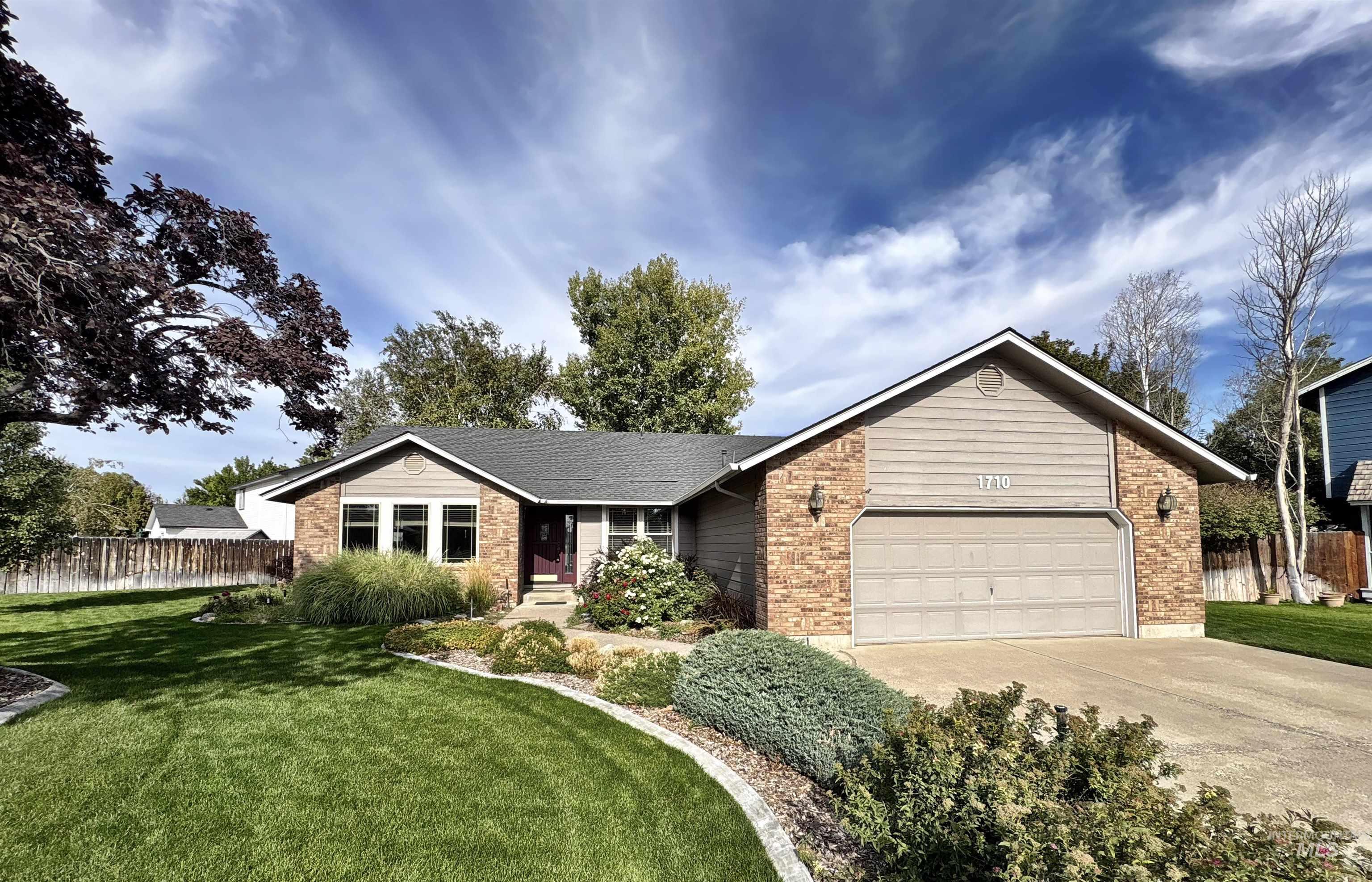 Ranch-style house with brick siding, concrete driveway, and an attached garage