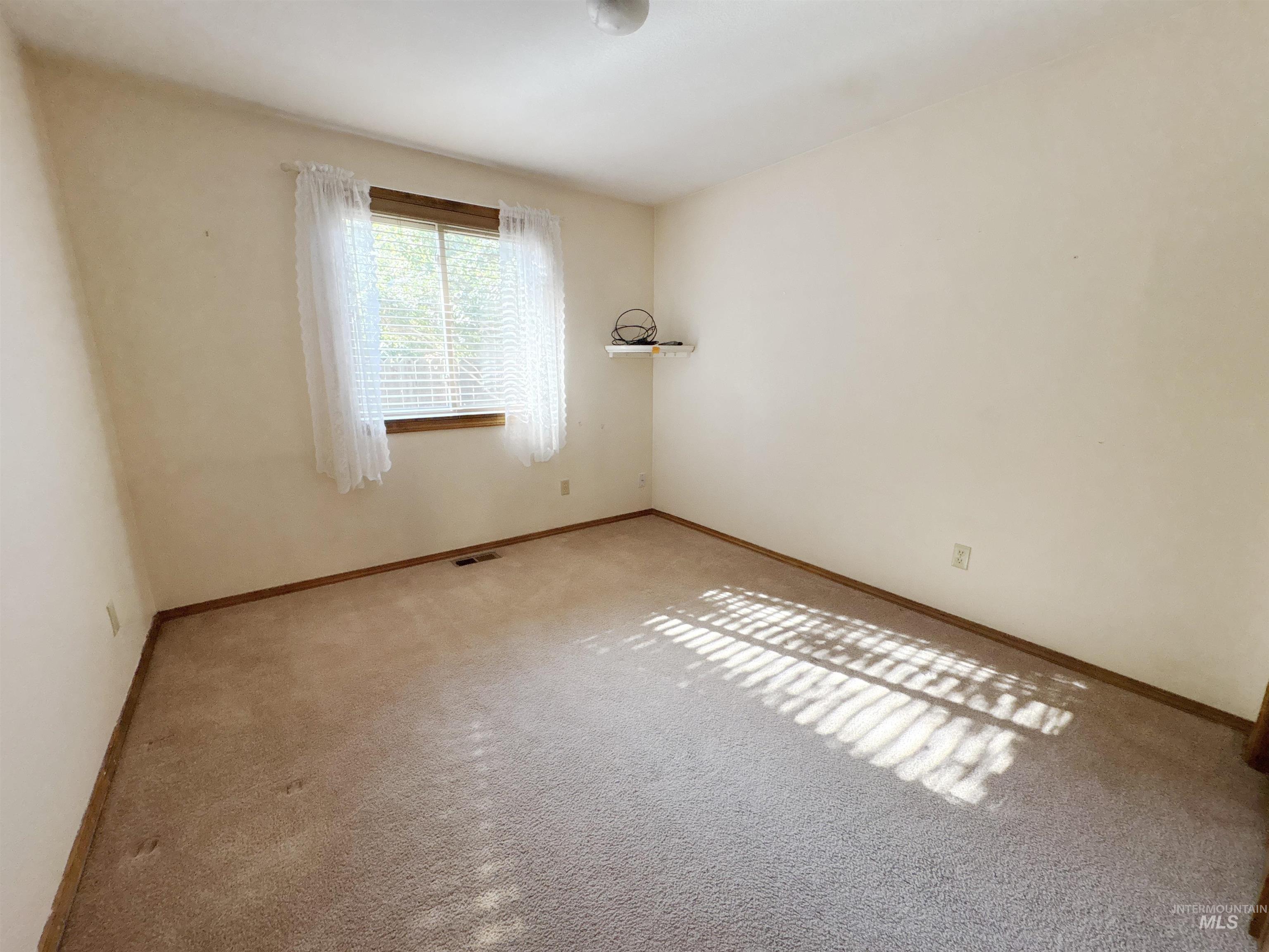 Empty room with baseboards and carpet