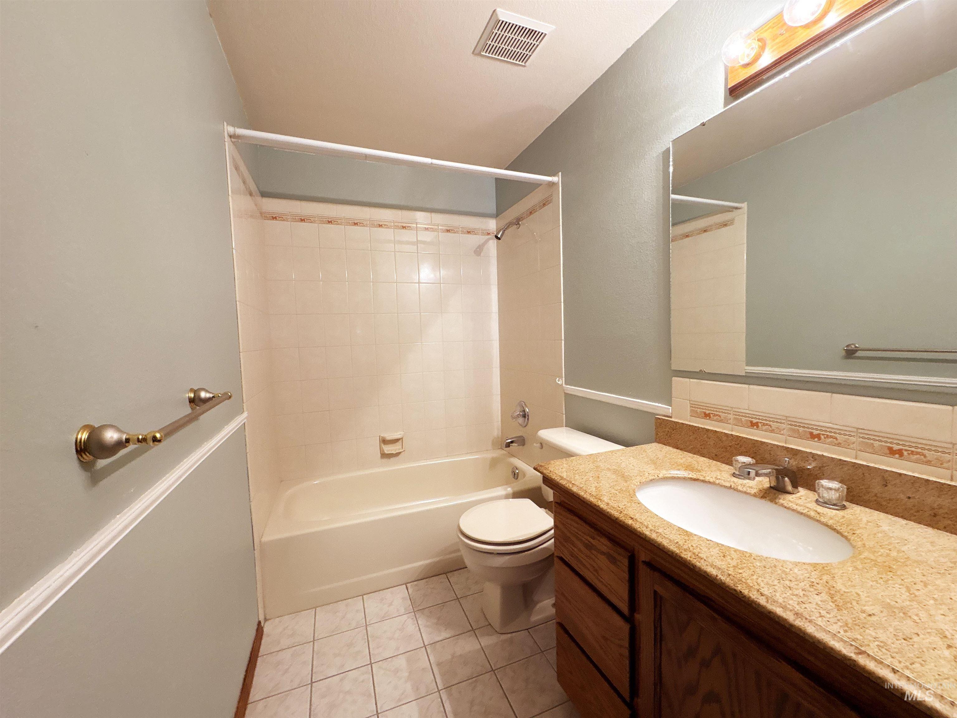 Bathroom with shower / bathtub combination, vanity, and light tile patterned floors