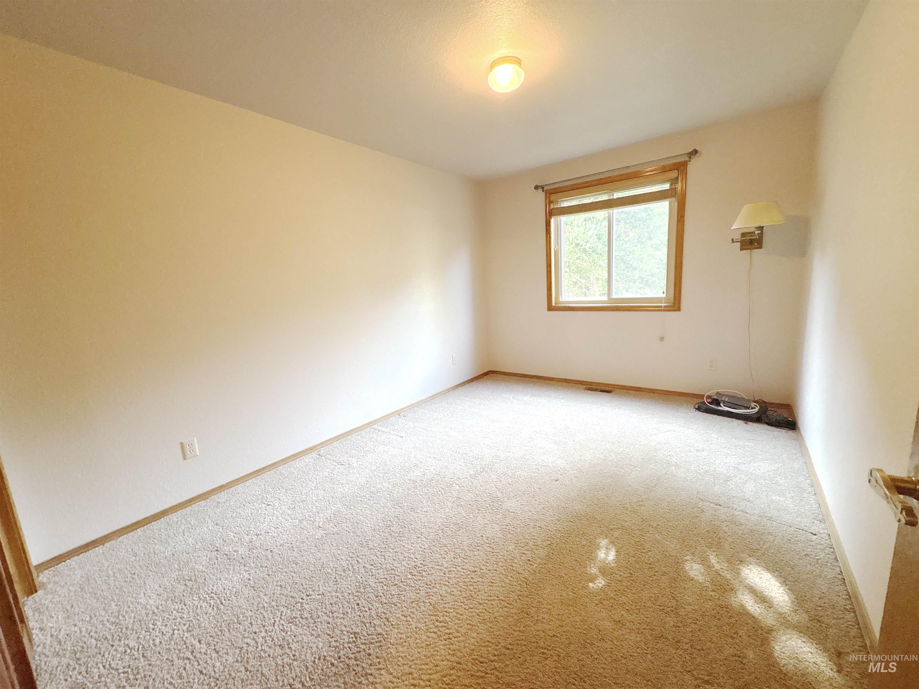 Empty room featuring carpet flooring and baseboards