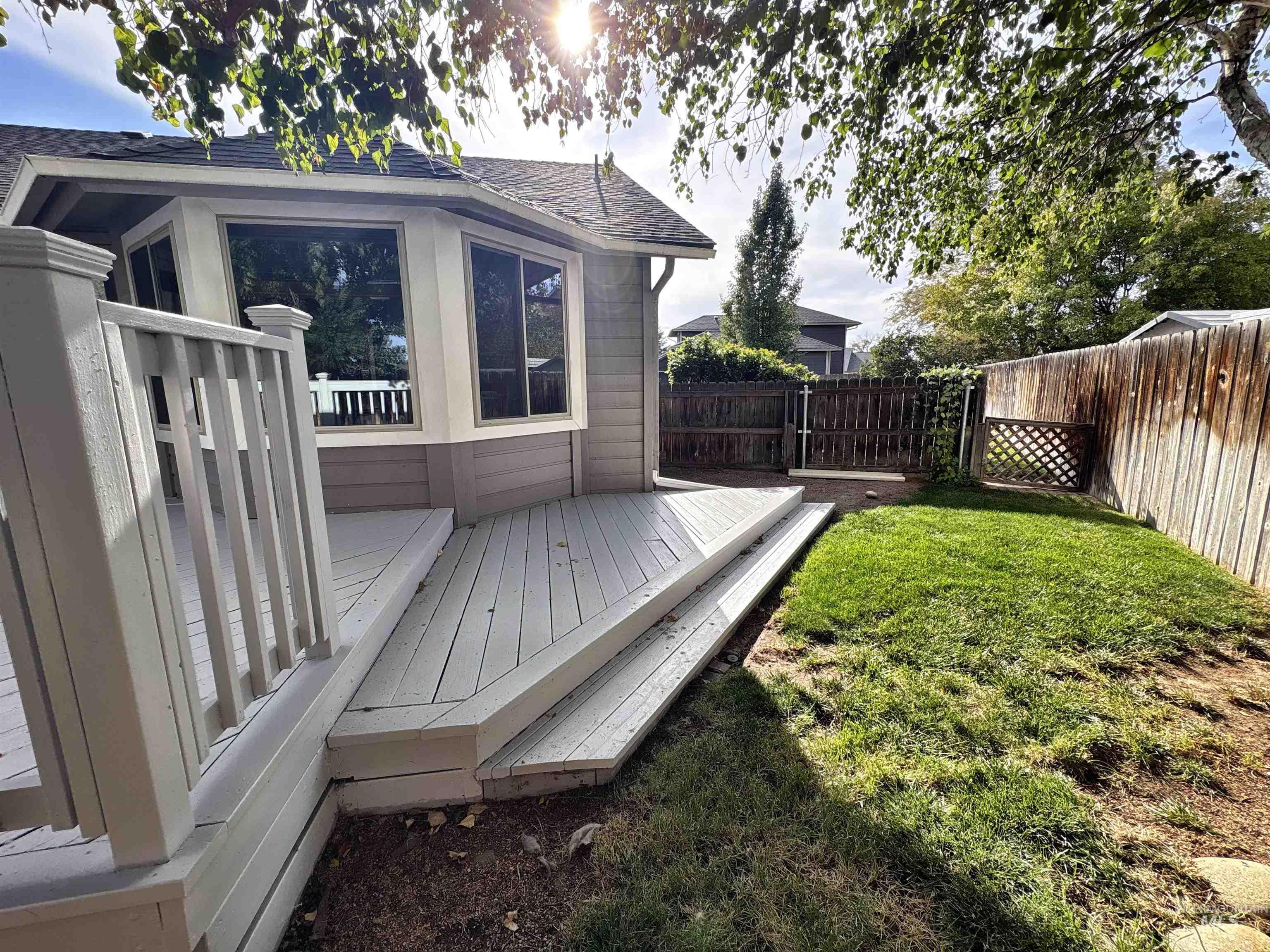 Wooden deck with a fenced backyard