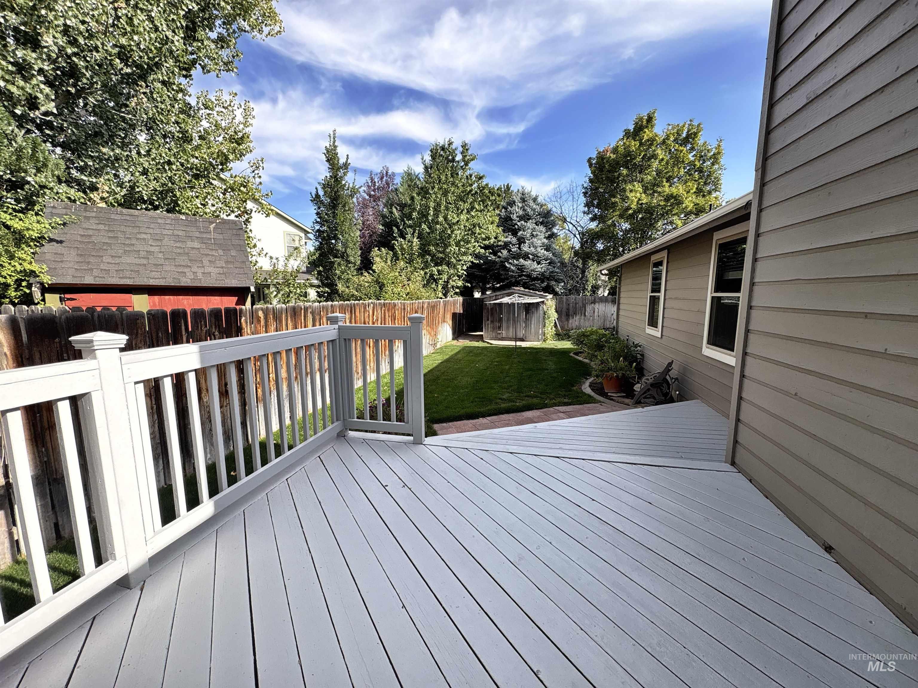 Deck with a fenced backyard and a storage shed