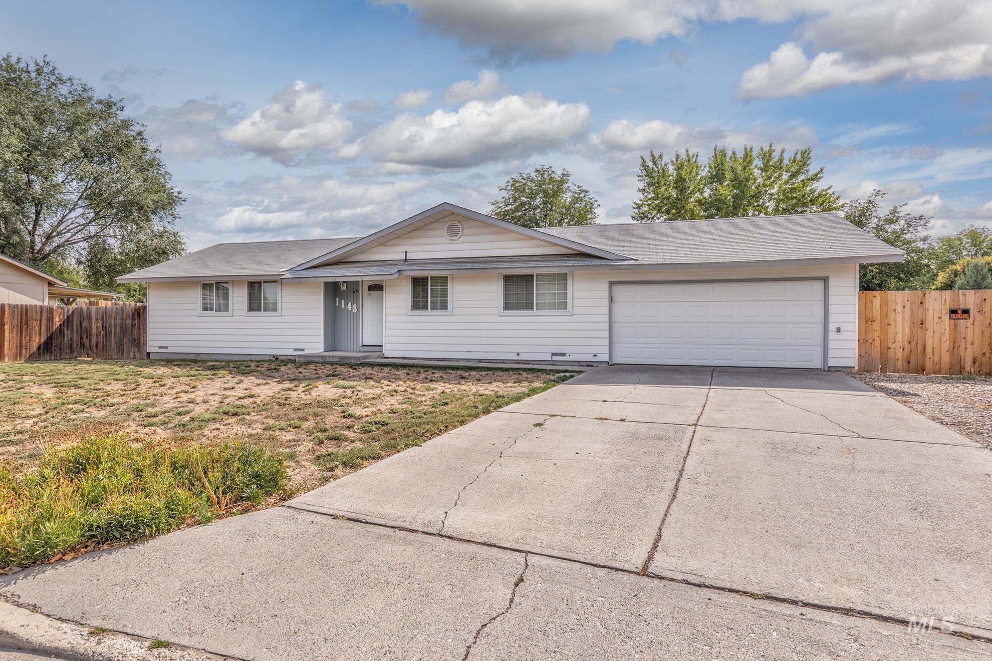 Ranch-style house with driveway, a garage, and a shingled roof
