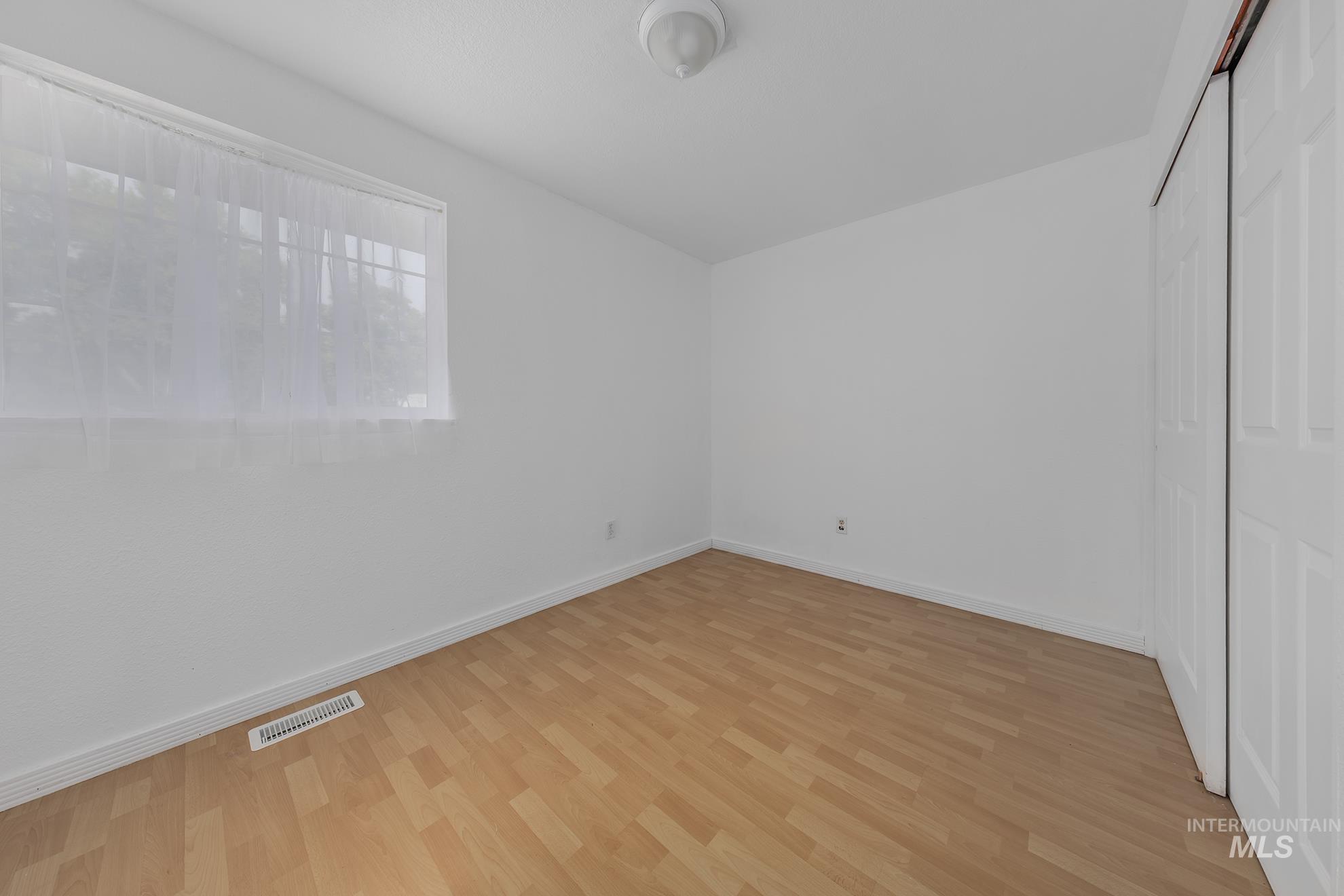 Unfurnished bedroom featuring light wood-style flooring and a closet