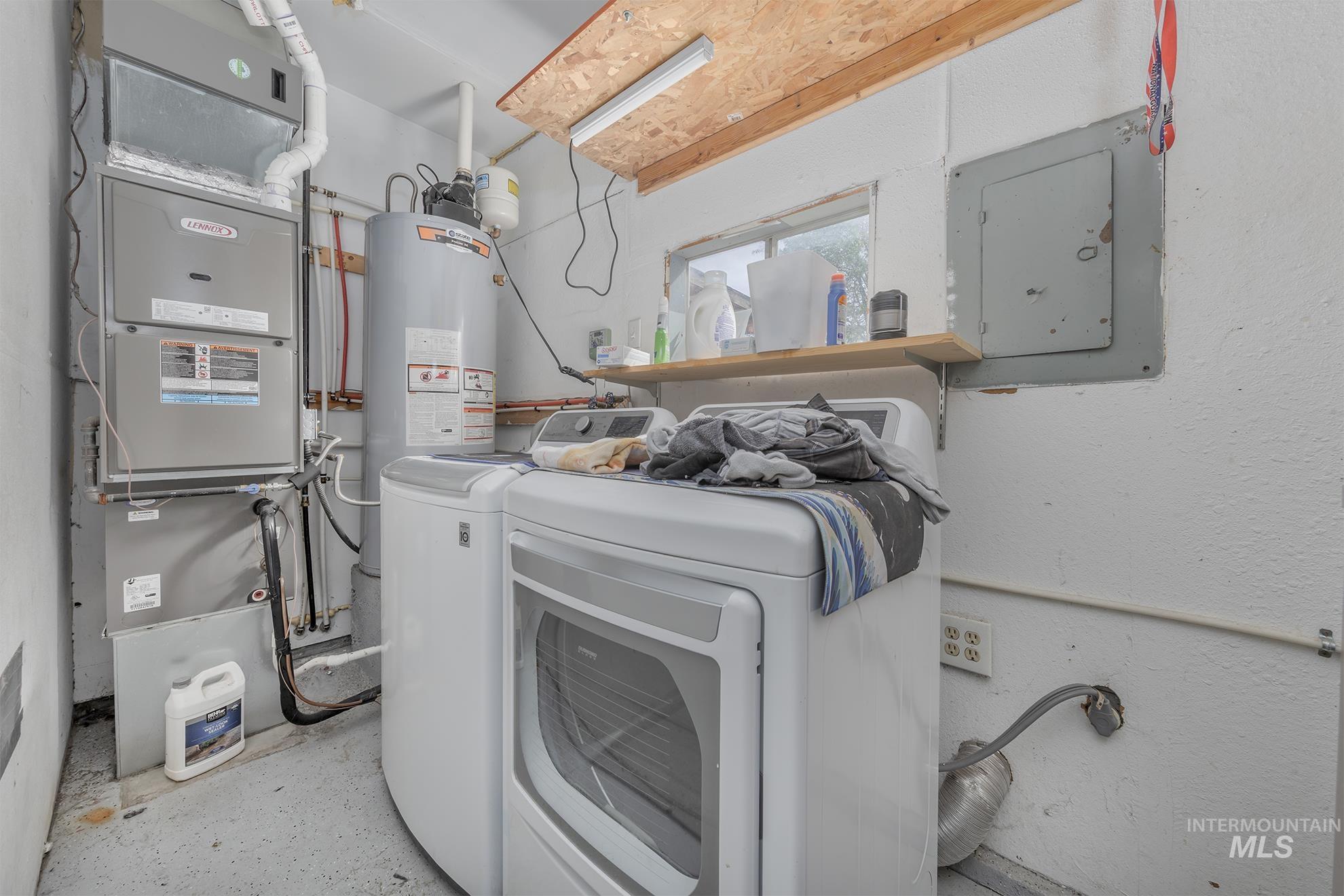 Washroom with electric panel, heating unit, separate washer and dryer, and water heater