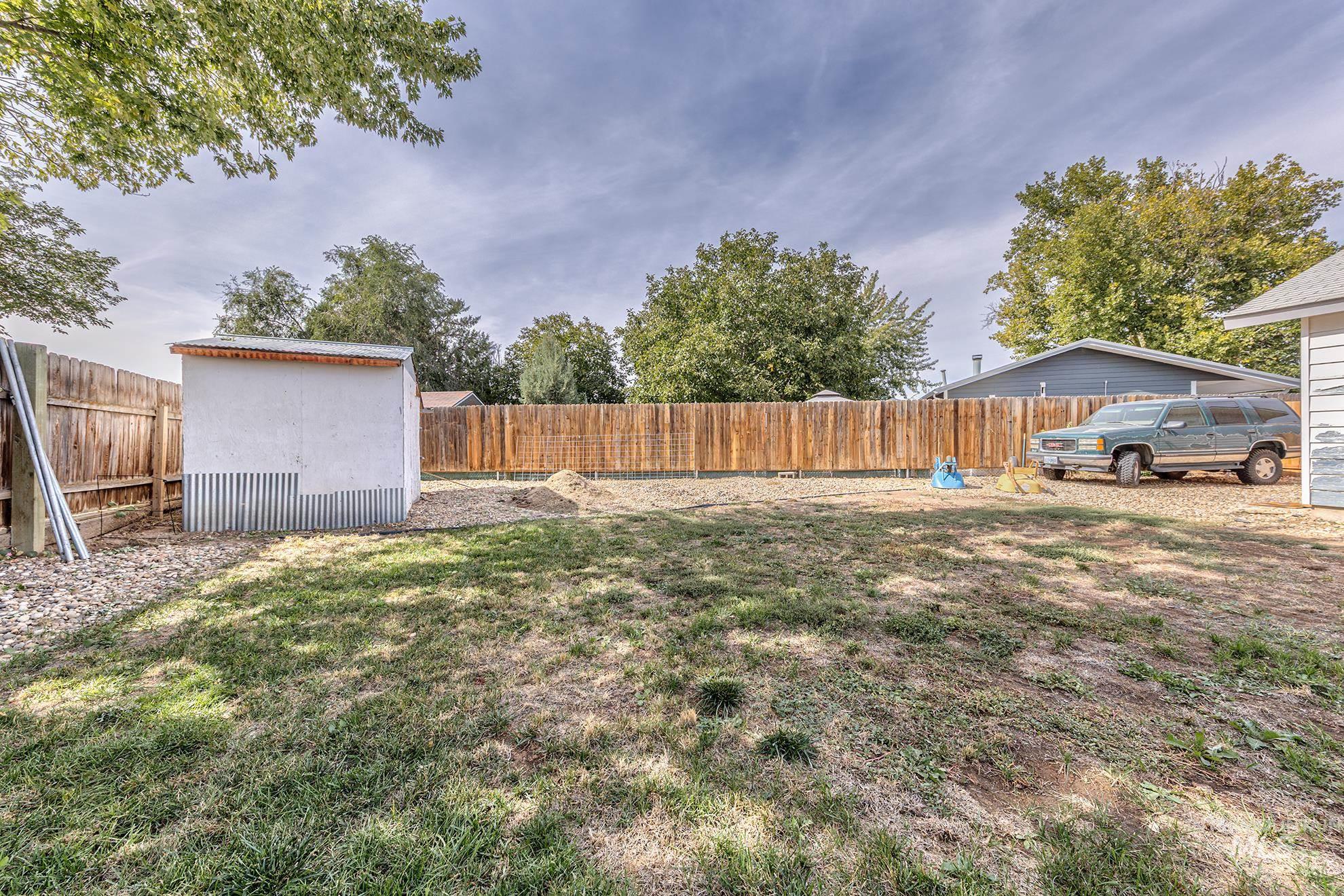 Fenced backyard featuring a storage shed