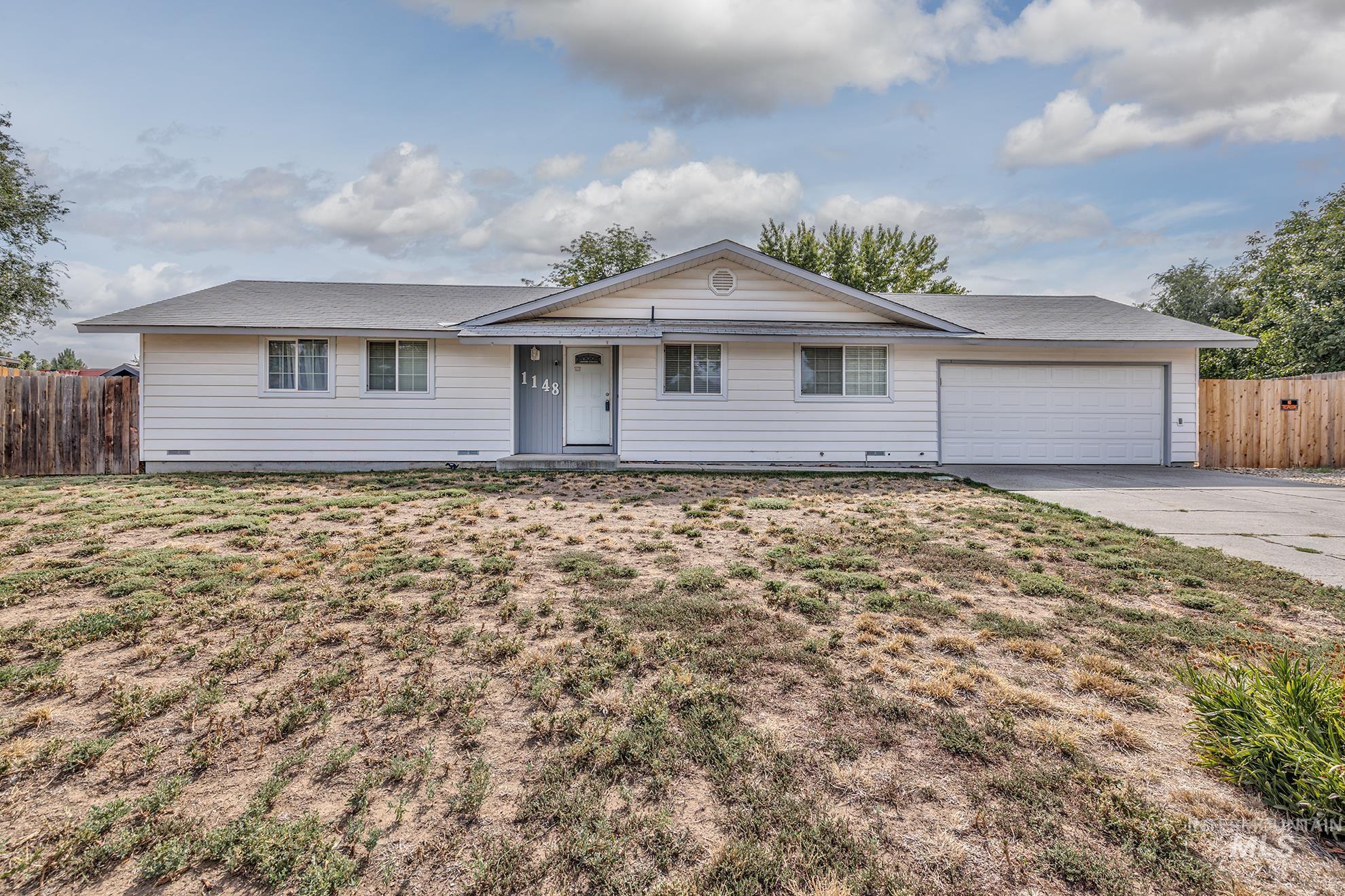Single story home featuring concrete driveway and an attached garage
