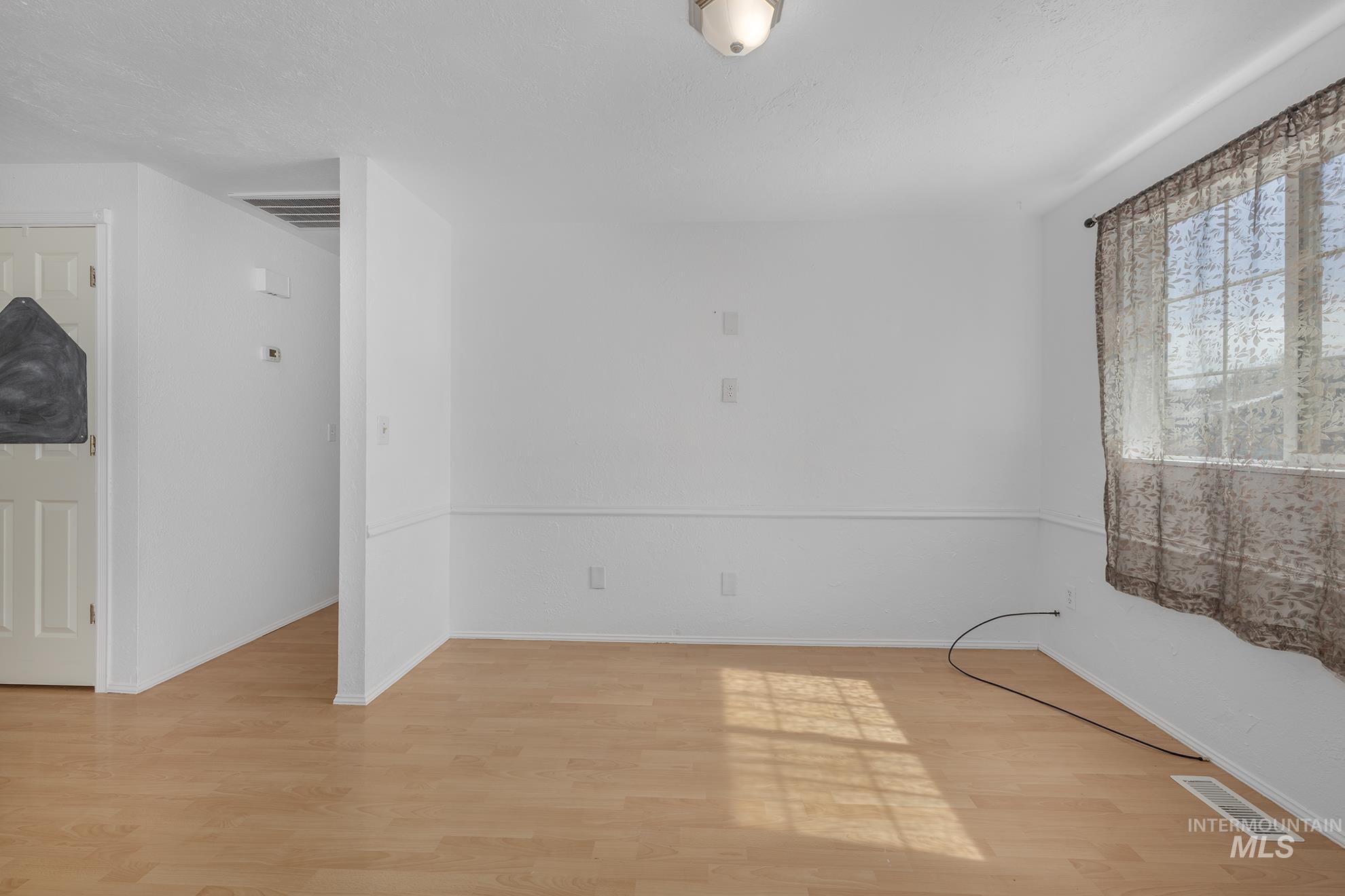 Spare room with light wood-type flooring and baseboards