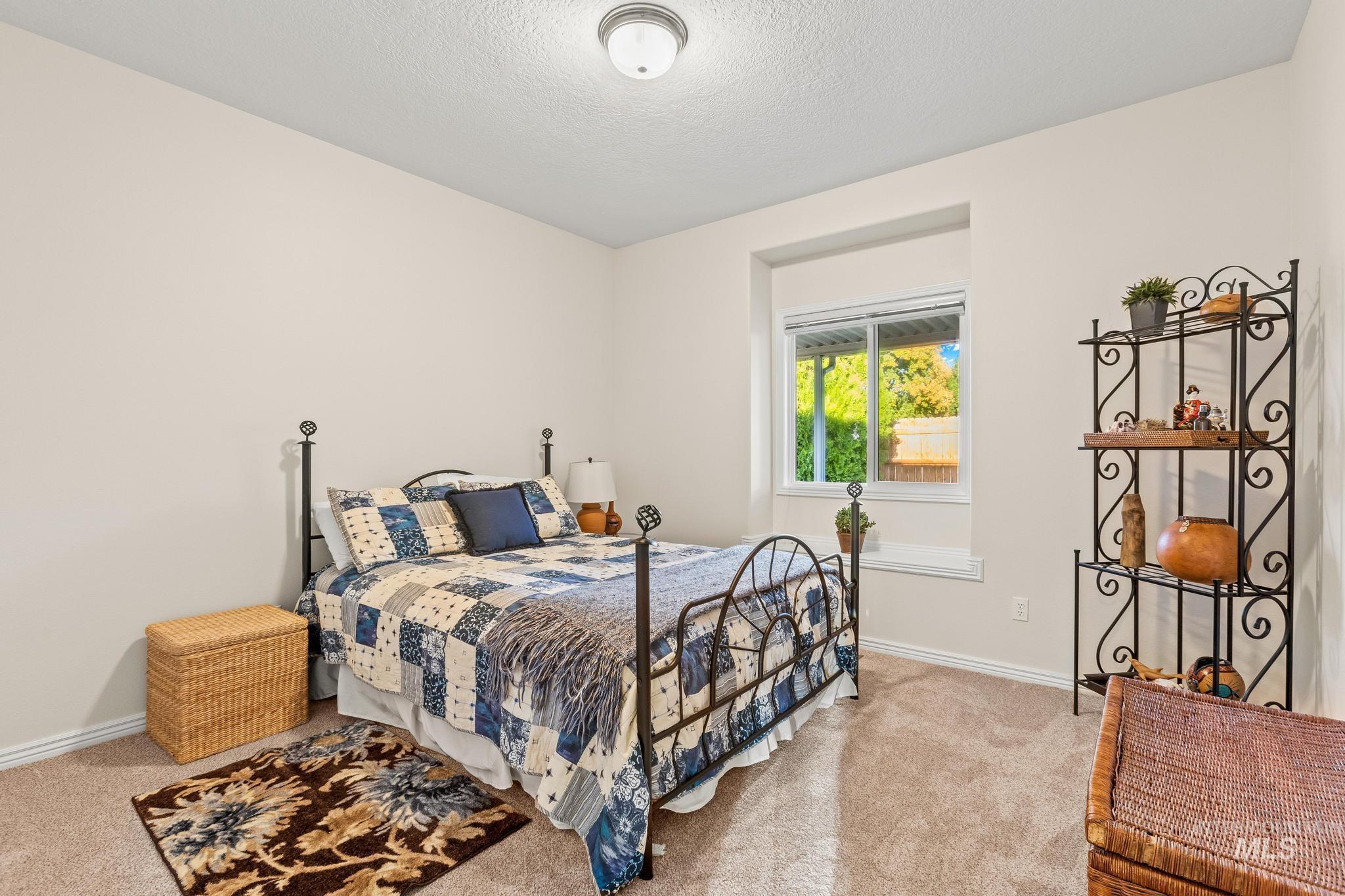 Bedroom with light carpet and a textured ceiling