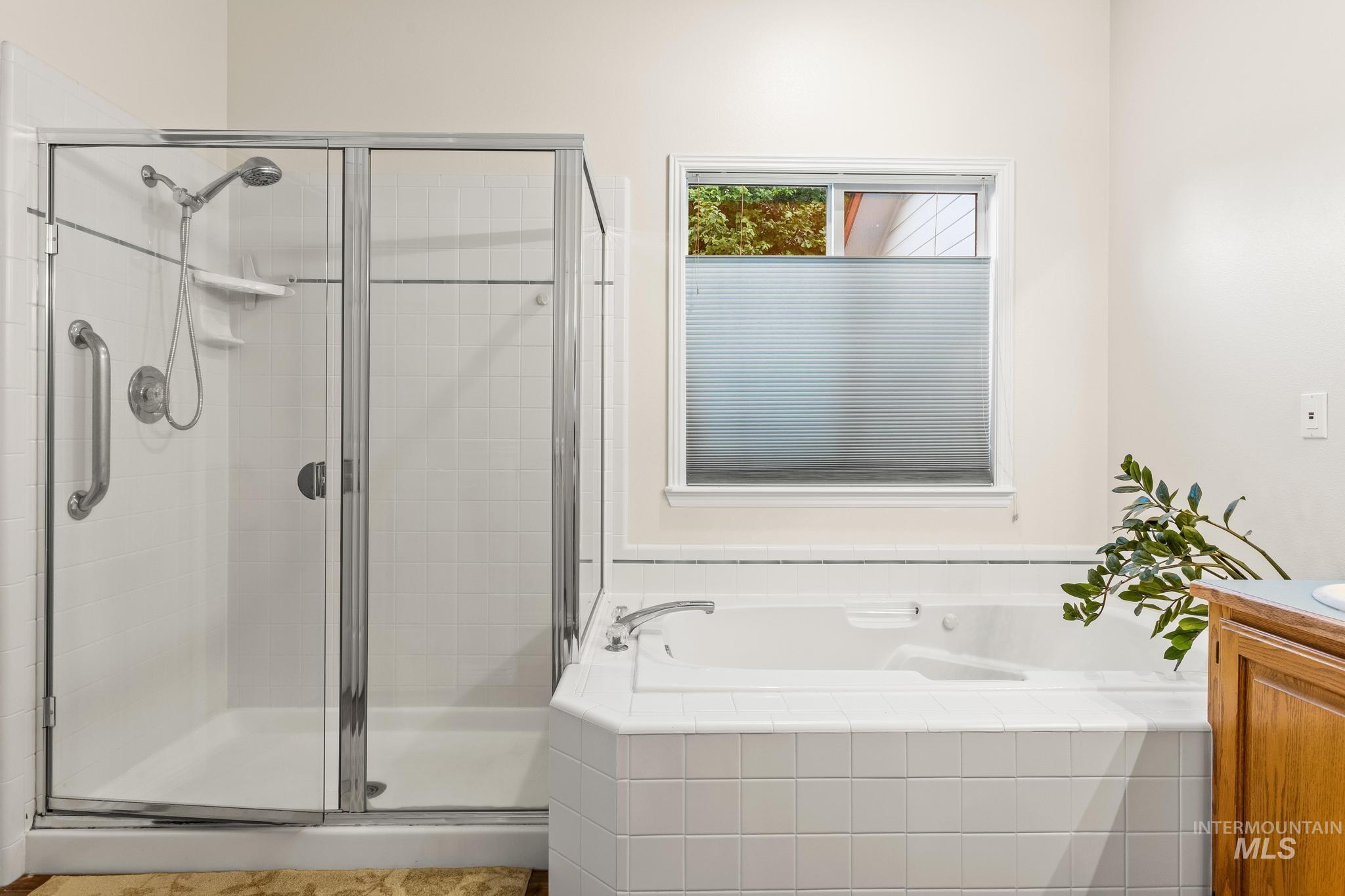 Full bath with a shower stall, vanity, and a bath