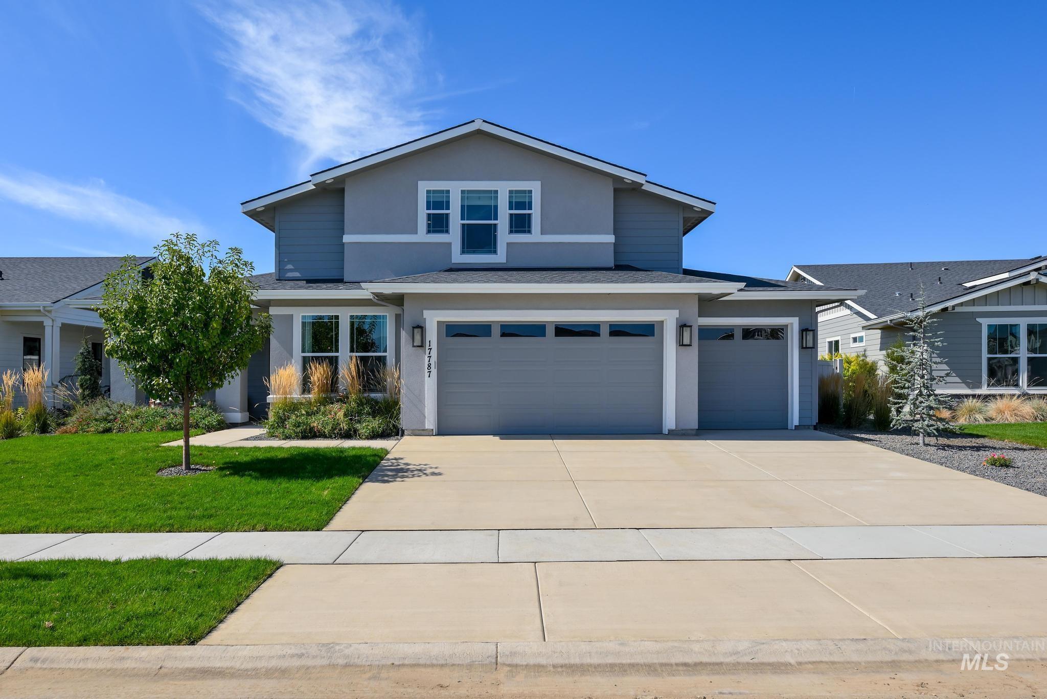 View of front of home with a shingled roof, driveway, stucco siding, and an attached garage