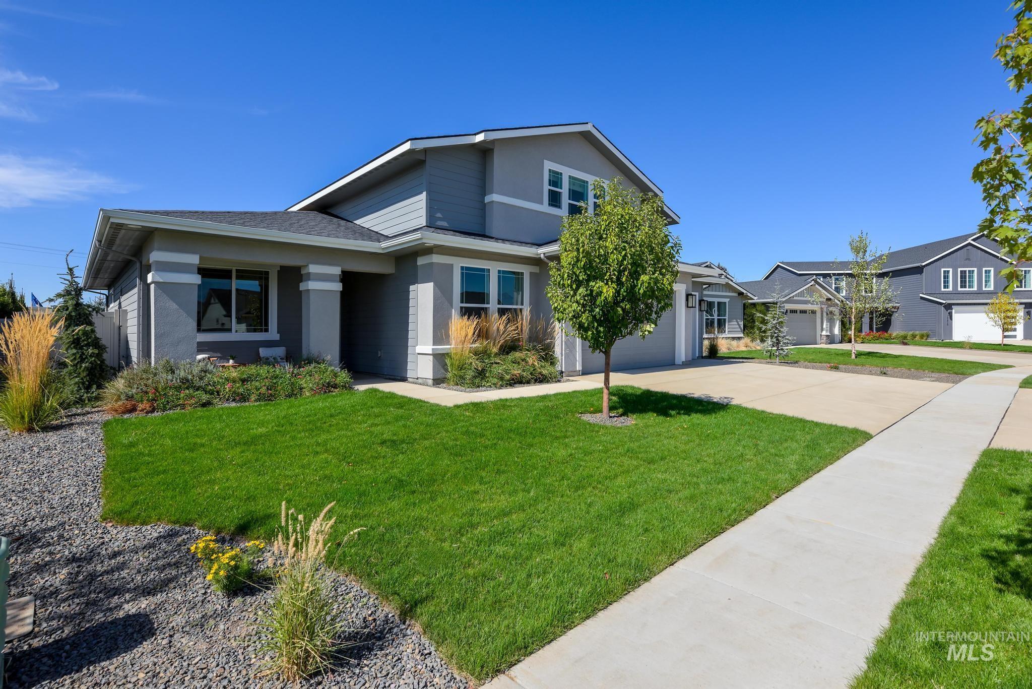 View of front of house with driveway, a front lawn, stucco siding, and a garage