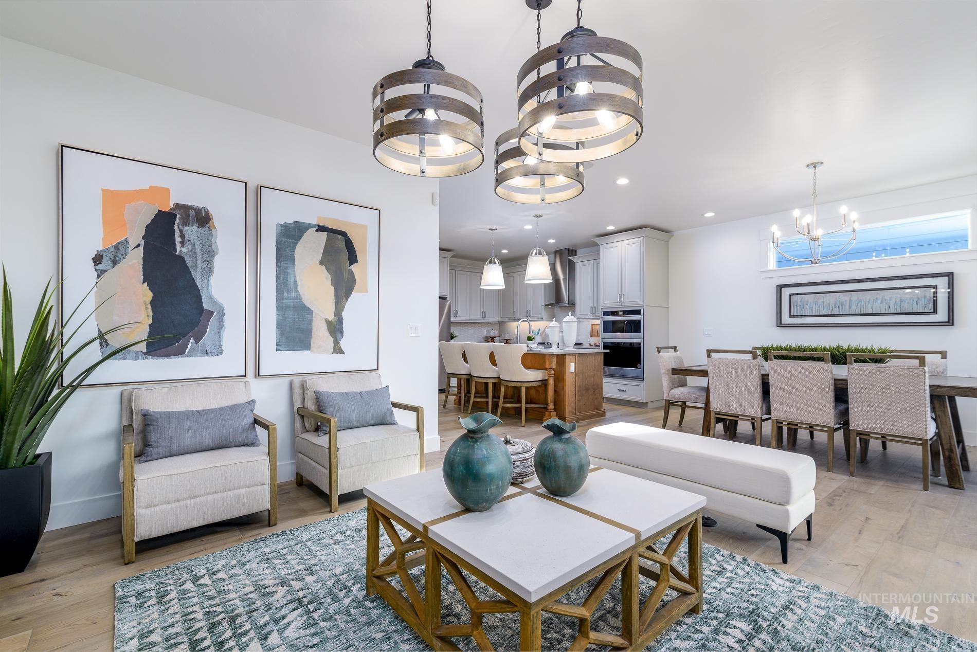 Living room with a chandelier, light wood-type flooring, and recessed lighting