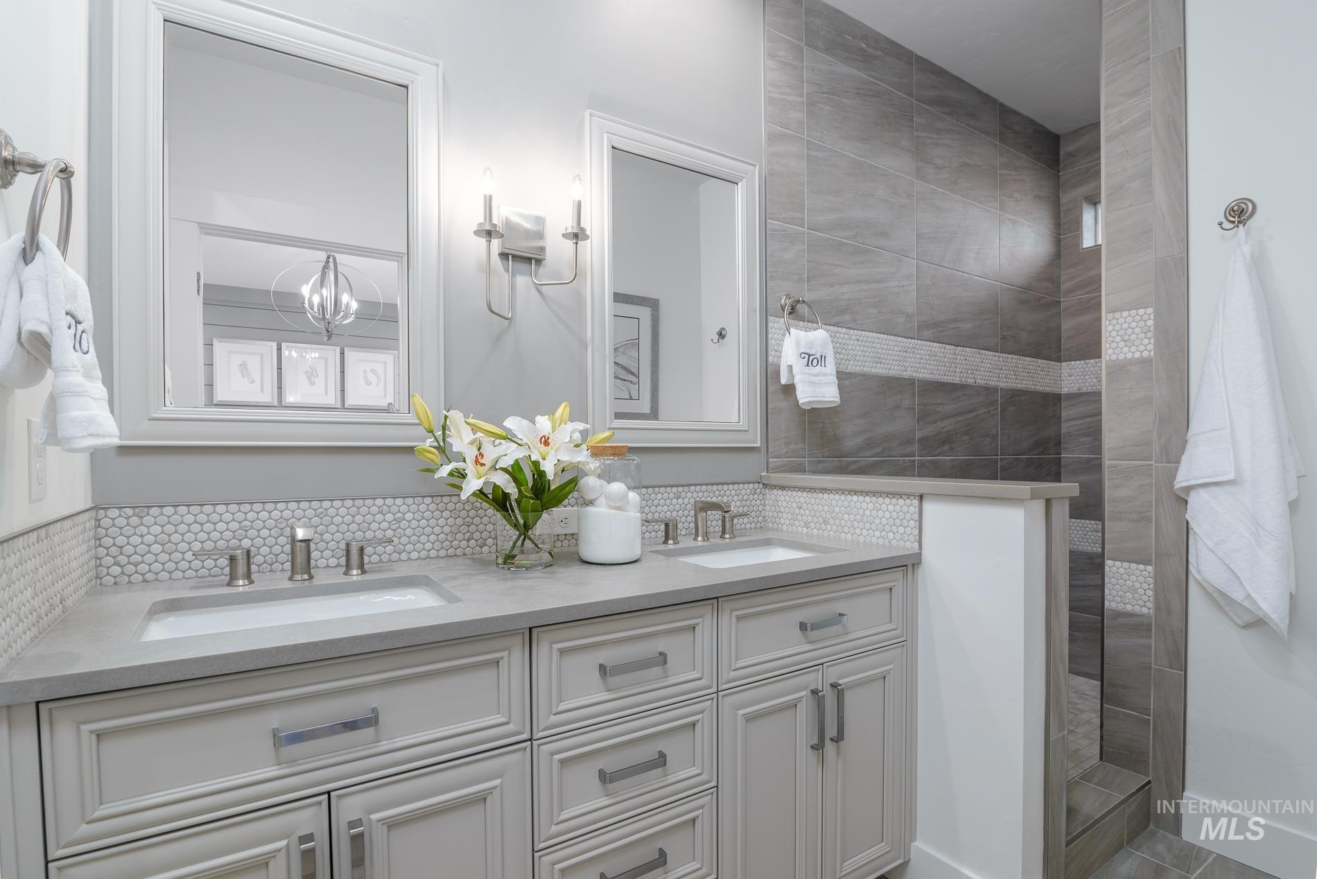 Full bathroom with a walk in shower, double vanity, and backsplash